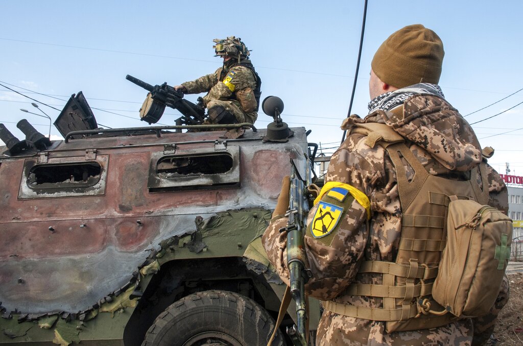 Ukrainian soldiers inspect a damaged military vehicle after fighting in Kharkiv, Ukraine, Sunday, Feb. 27, 2022. The city authorities said that Ukrainian forces engaged in fighting with Russian troops that entered the country's second-largest city on Sunday. (AP Photo/Marienko Andrew)