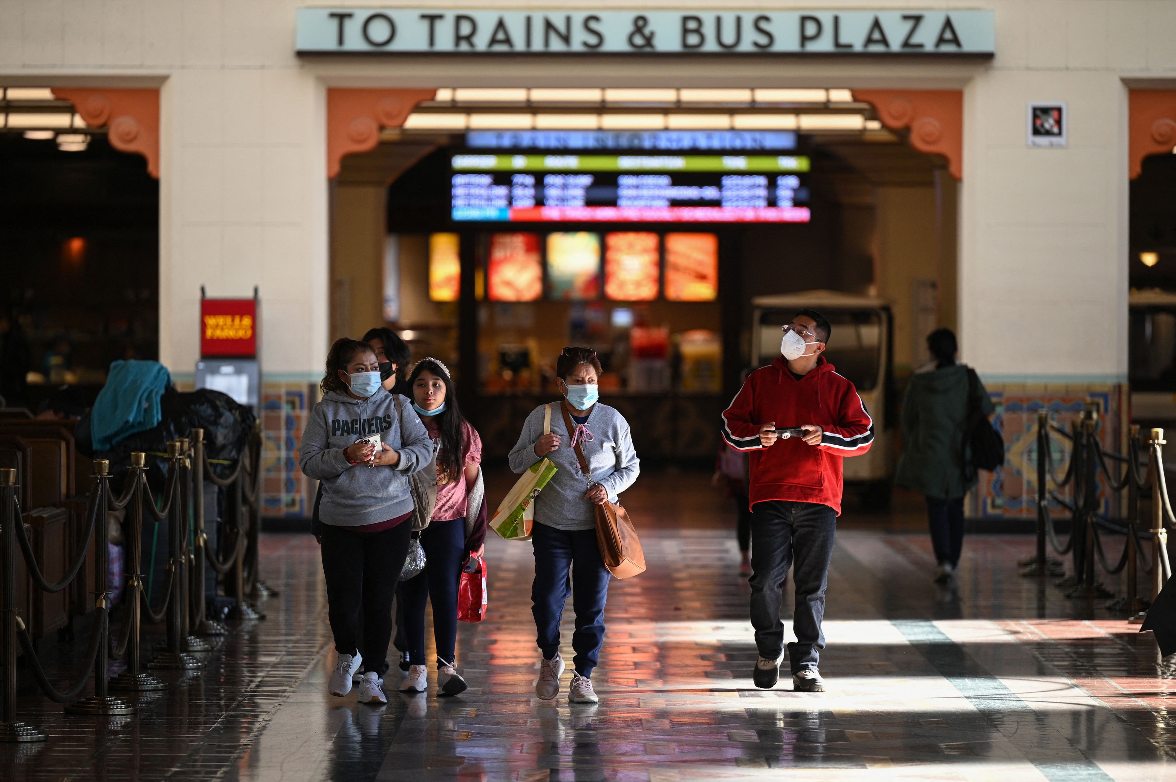 A family wearing face masks walks through Union Station in Los Angeles, California, Jan. 5, 2022. (ROBYN BECK/AFP via Getty Images)