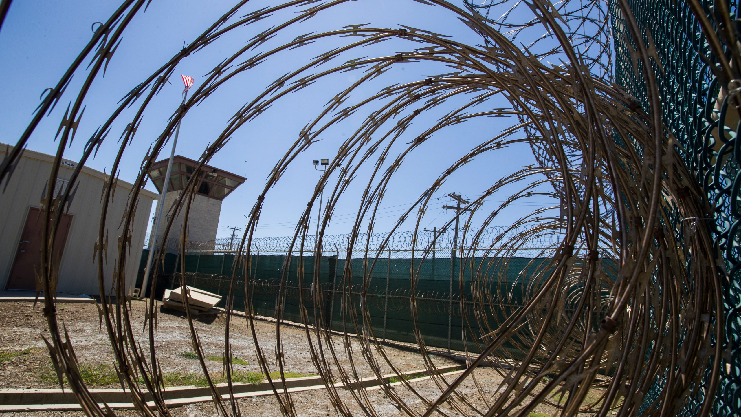 In this April 17, 2019, photo, reviewed by U.S. military officials, the control tower is seen through the razor wire inside the Camp VI detention facility in Guantanamo Bay Naval Base, Cuba. The Biden administration has been quietly laying the groundwork to release prisoners from the Guantanamo Bay detention center and at least move closer to being able to shut it down. (AP Photo/Alex Brandon, File)