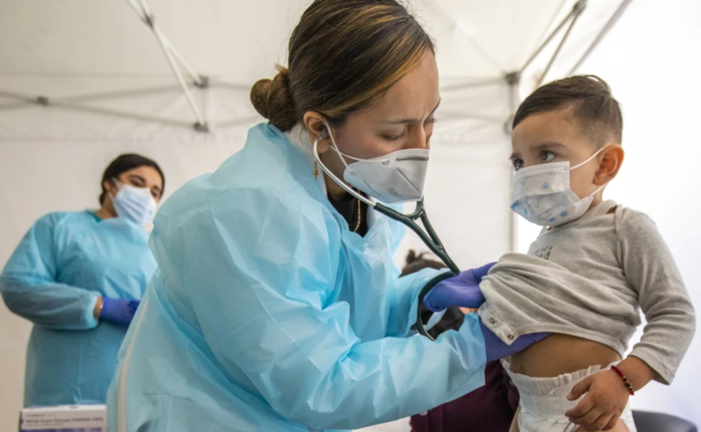 Dr. Faraiba Faqeerzada examines a 2-year-old at South Central Family Health Center in Los Angeles. The center is in a neighborhood with the highest Omicron case rates in the county.(Francine Orr / Los Angeles Times)