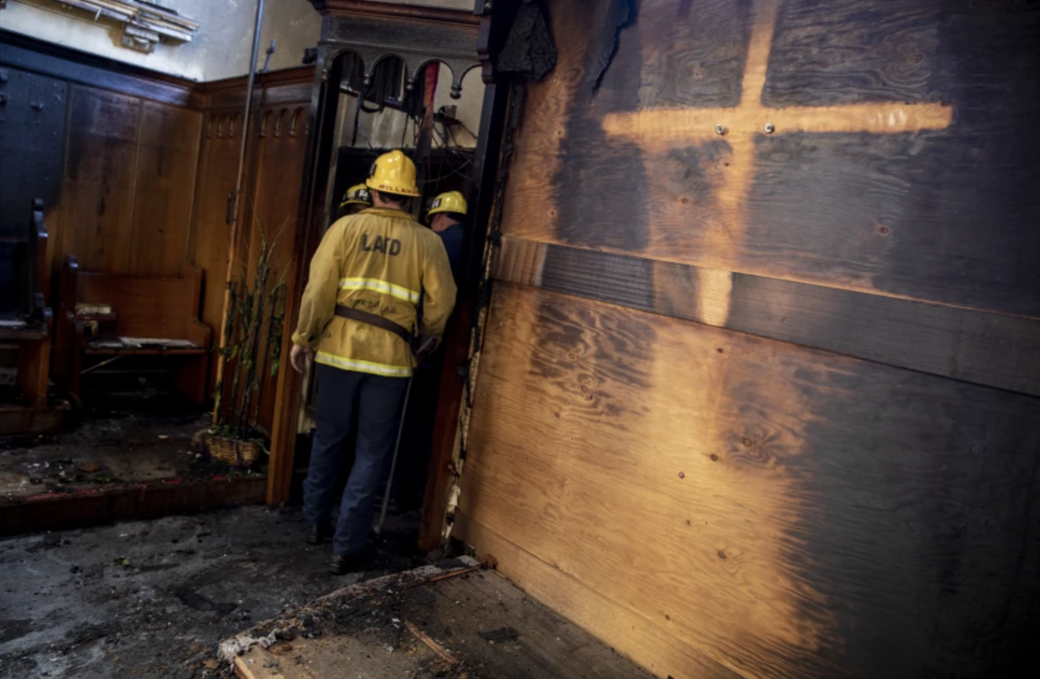 Authorities examine the aftermath of a fire Sunday at St. John’s United Methodist Church in Watts, where flames left a silhouette of a cross.(Brian van der Brug / Los Angeles Times)