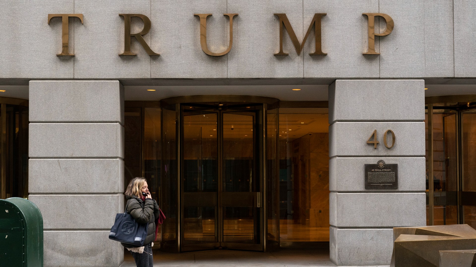 A woman walks past the Trump Building in New York's financial district, Wednesday, Jan. 13, 2021. Mazars USA LLP, the accounting firm that prepared former President Donald Trump’s annual financial statements, says the documents “should no longer be relied upon” after investigators said they found evidence he and his company regularly misstated the value of assets. (AP Photo/Mark Lennihan, File)