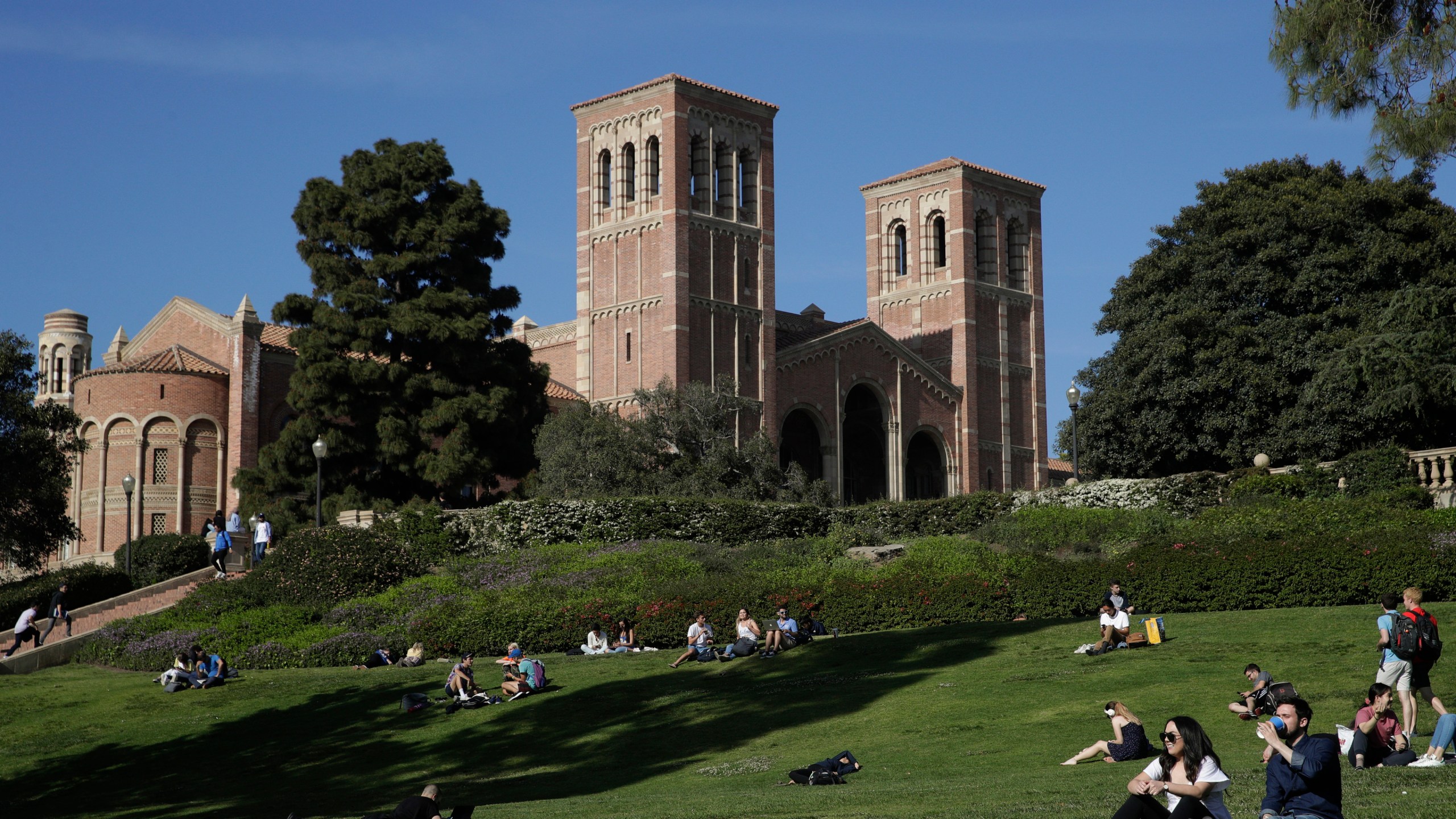 Students sit on the lawn near Royce Hall at the University of California, Los Angeles, in the Westwood section of Los Angeles on April 25, 2019. Matthew Harris, a former lecturer at UCLA, was arrested last week in Colorado after he allegedly emailed an 800-page document and posted videos threatening violence against dozens of people at the university. A trail of red flags about his behavior toward women followed Harris on an academic journey that took him to three of the nation’s most prestigious universities — Duke, Cornell and then the University of California, Los Angeles. (AP Photo/Jae C. Hong, File)