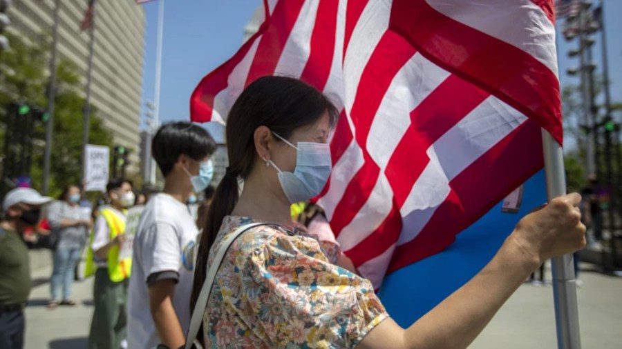 A demonstrator holds an American flag in Grand Park in downtown Los Angeles during a Youth Against Hate rally last spring.(Francine Orr / Los Angeles Times)