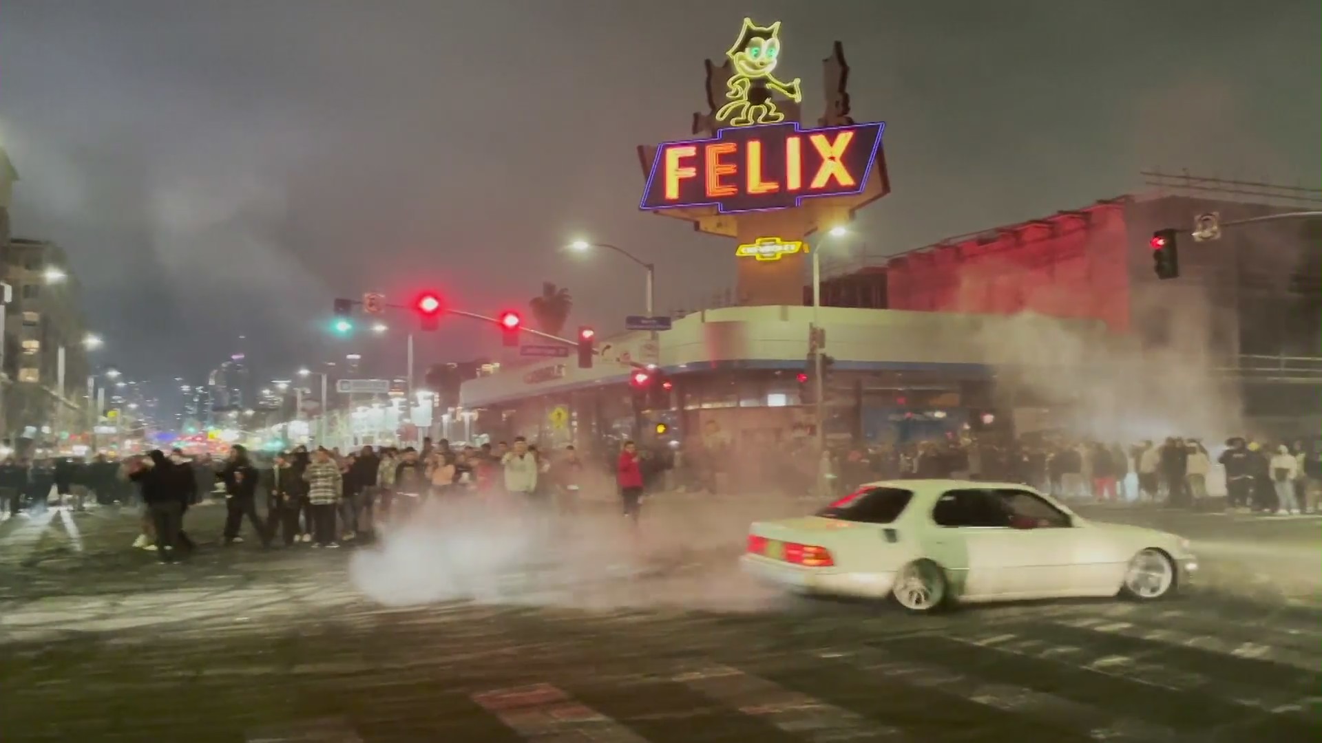 A vehicle is seen doing doughnuts around a crowd of spectators in South Los Angeles on Feb. 20, 2022. (OnScene.TV)