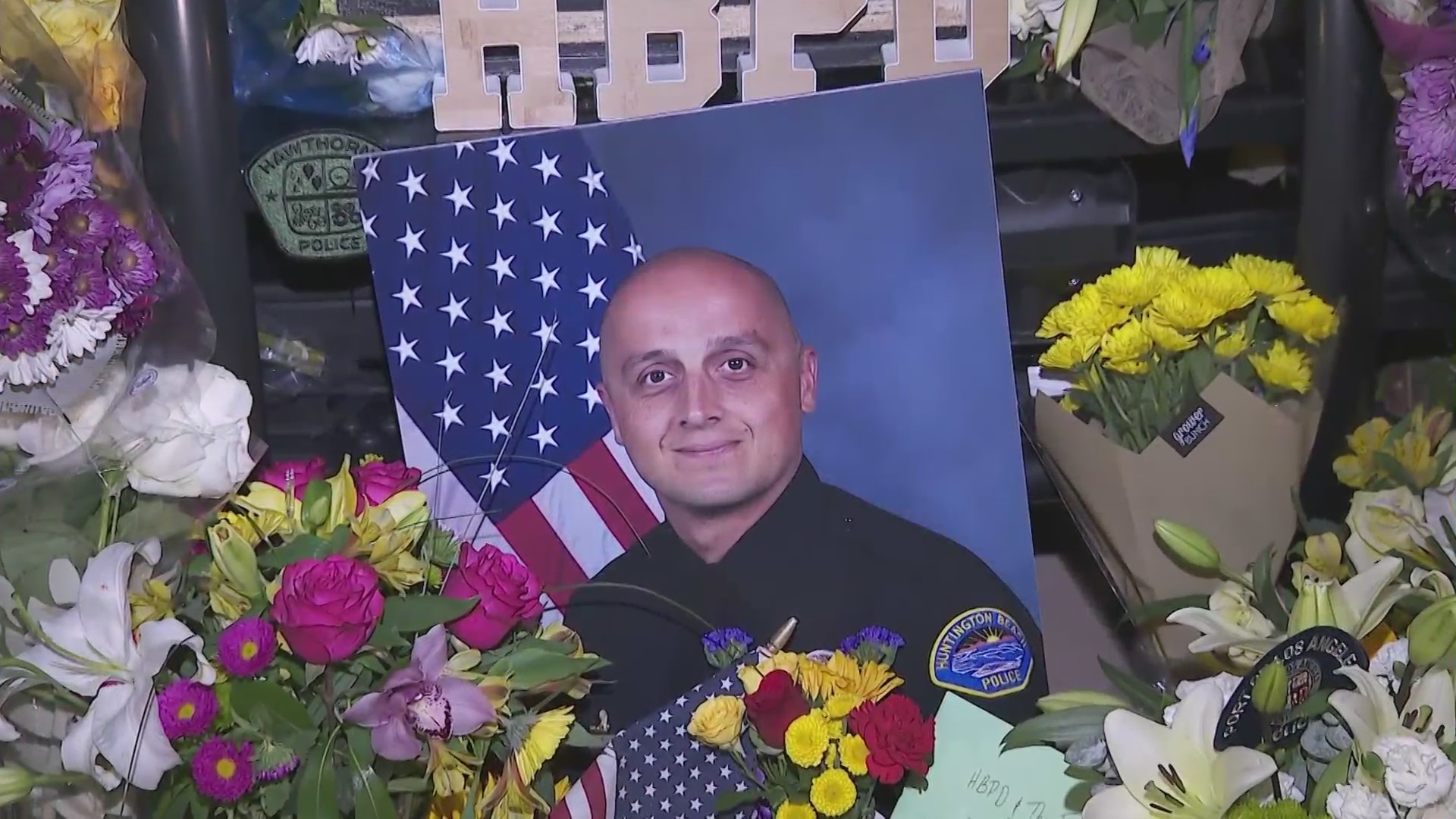 Officer Nicholas Vella is seen in a photo placed at a memorial in Huntington Beach. (KTLA)