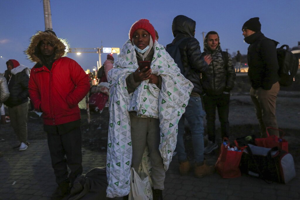 A student covers herself in blanket at the Medyka border crossing after fleeing from the Ukraine, in Poland, Monday, Feb. 28, 2022. The head of the United Nations refugee agency says more than a half a million people had fled Ukraine since Russia's invasion on Thursday. (AP Photo/Visar Kryeziu)