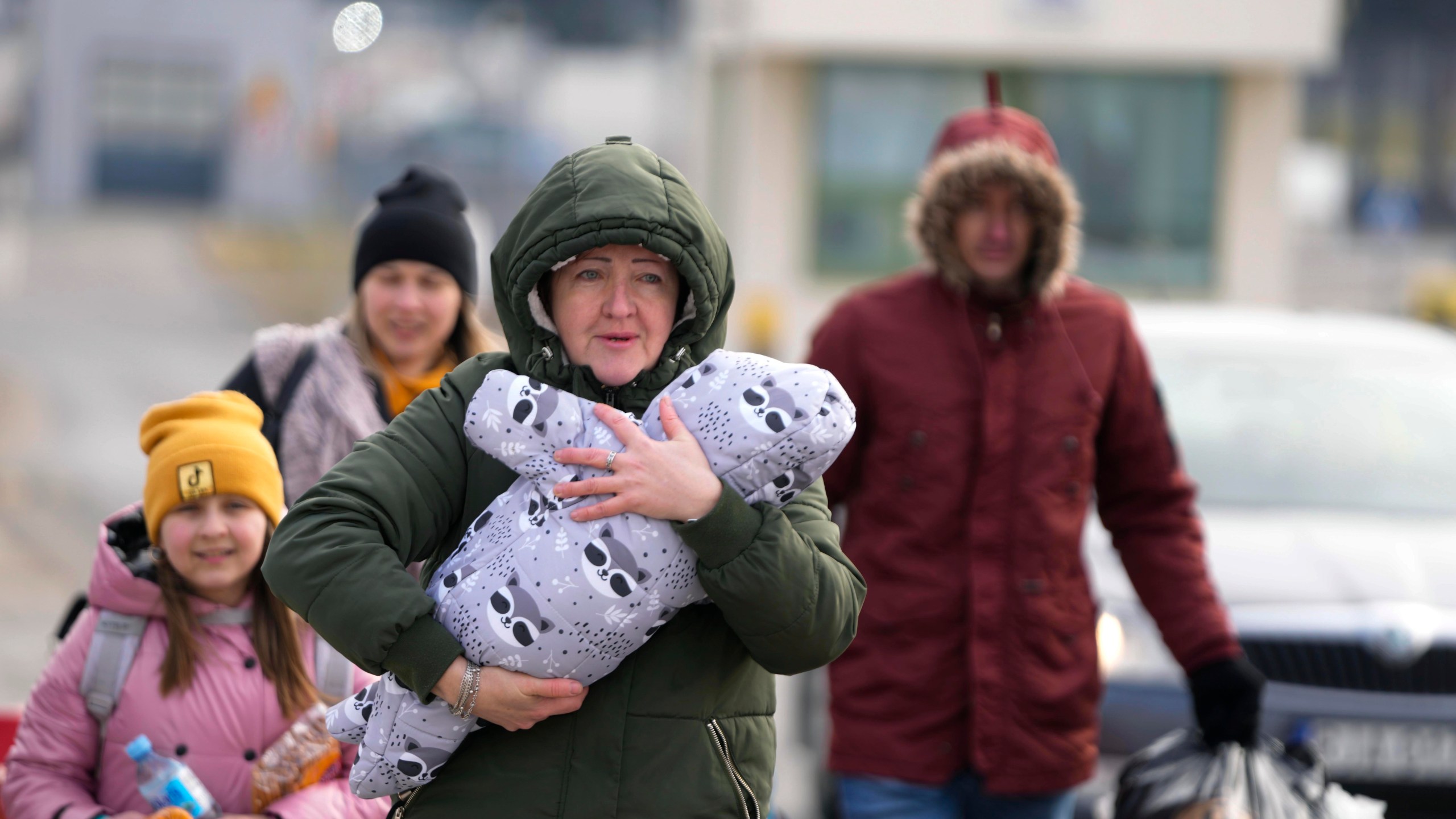 A family arrive at the border crossing in Medyka, Poland, Wednesday, March 2, 2022, after fleeing from the Ukraine. The U.N. refugee agency said Tuesday that around 660,000 people have fled Ukraine for neighboring countries since the Russian invasion began. (AP Photo/Markus Schreiber)