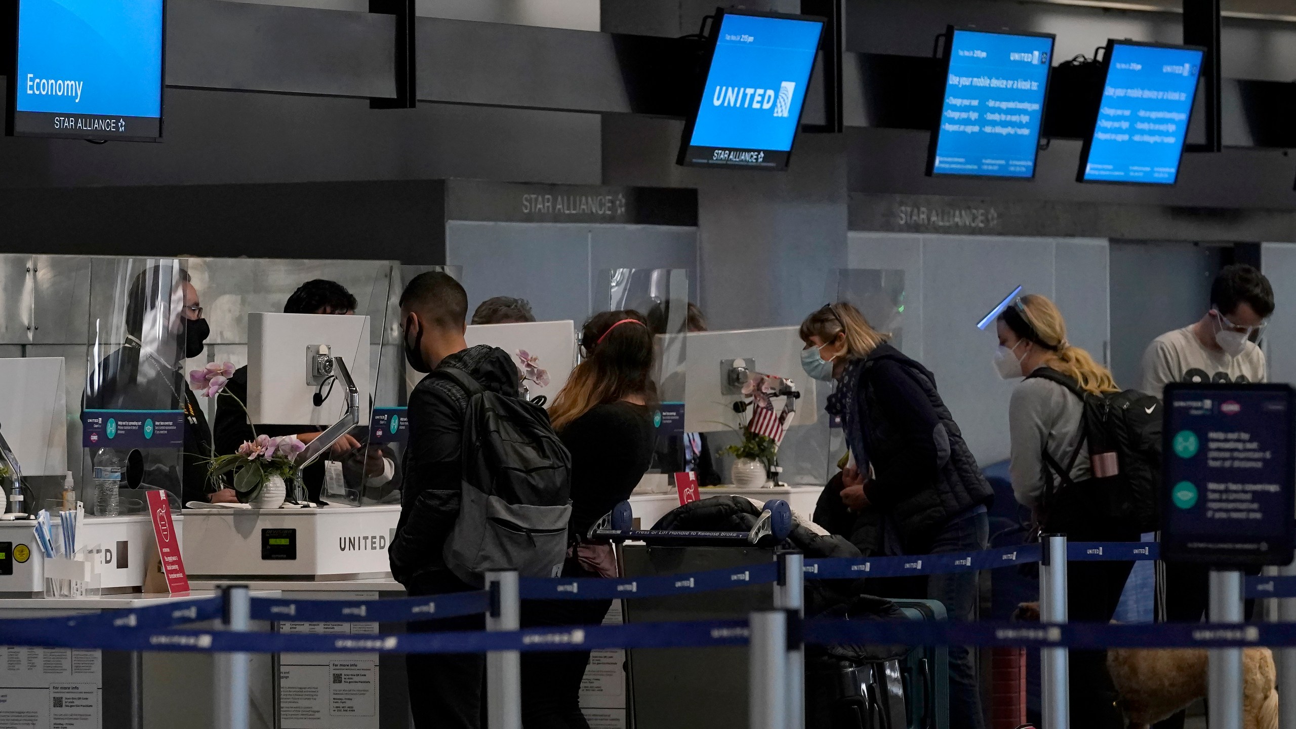 Travelers check in at United desks at San Francisco International Airport during the coronavirus outbreak in San Francisco, Tuesday, Nov. 24, 2020. The airline industry is raising the stakes in a fight over mandatory rest breaks under California law. A study commissioned by an airline trade group and released Tuesday, March 15, 2022, warns that unless the U.S. Supreme Court acts, travelers will face fewer flight options and higher fares.(AP Photo/Jeff Chiu)