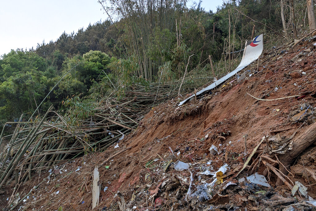 In this photo taken by mobile phone released by Xinhua News Agency, a piece of wreckage of the China Eastern's flight MU5735 are seen after it crashed on the mountain in Tengxian County, south China's Guangxi Zhuang Autonomous Region on Monday, March 21, 2022. (Xinhua via AP)