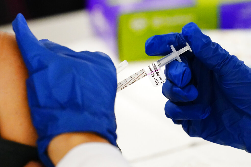 A health worker administers a dose of a Moderna COVID-19 vaccine during a vaccination clinic at the Norristown Public Health Center in Norristown, Pa., Tuesday, Dec. 7, 2021. (AP Photo/Matt Rourke, File)