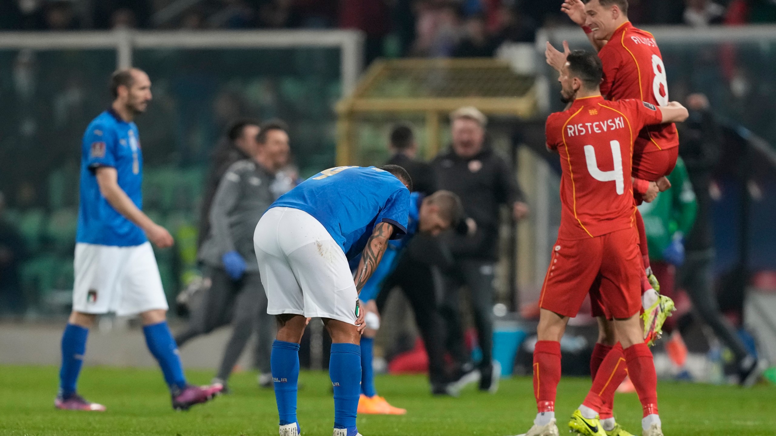 North Macedonia players celebrate as Italy players reacts after their team's elimination at the end of the World Cup qualifying play-off soccer match between Italy and North Macedonia, at Renzo Barbera stadium, in Palermo, Italy on March 24, 2022. North Macedonia won 1-0. (AP Photo/Antonio Calanni)