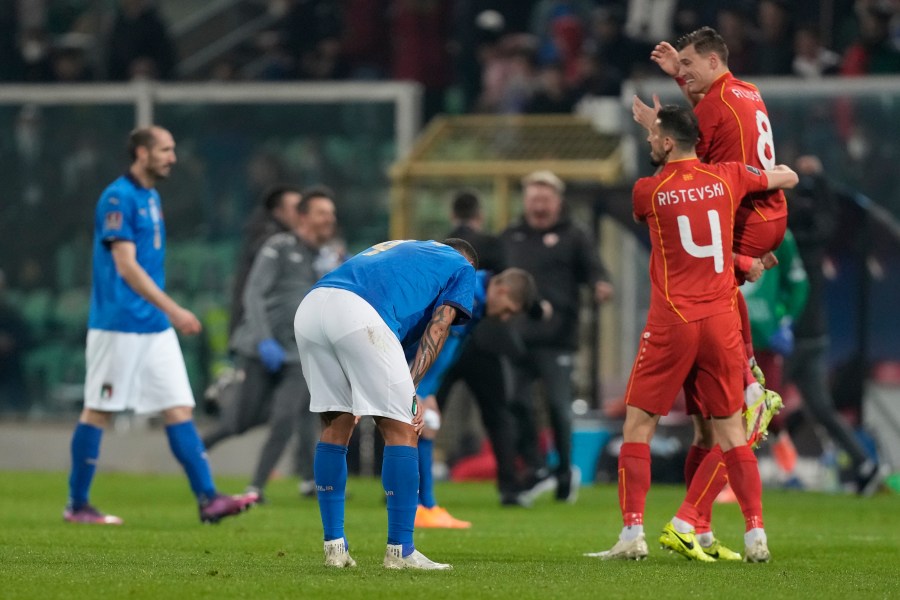 North Macedonia players celebrate as Italy players reacts after their team's elimination at the end of the World Cup qualifying play-off soccer match between Italy and North Macedonia, at Renzo Barbera stadium, in Palermo, Italy on March 24, 2022. North Macedonia won 1-0. (AP Photo/Antonio Calanni)