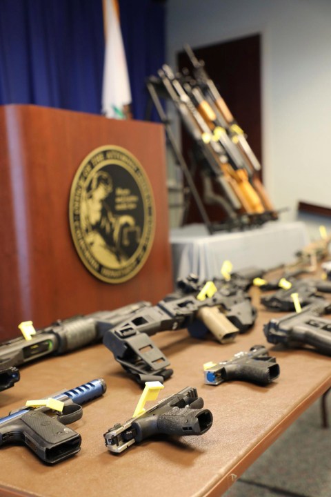 In this photo released by the California Department of Justice, illegal weapons seized by DOJ Agents are displayed during a news conference in Sacramento, Calif. on March 30, 2022. (California Department of Justice via AP)