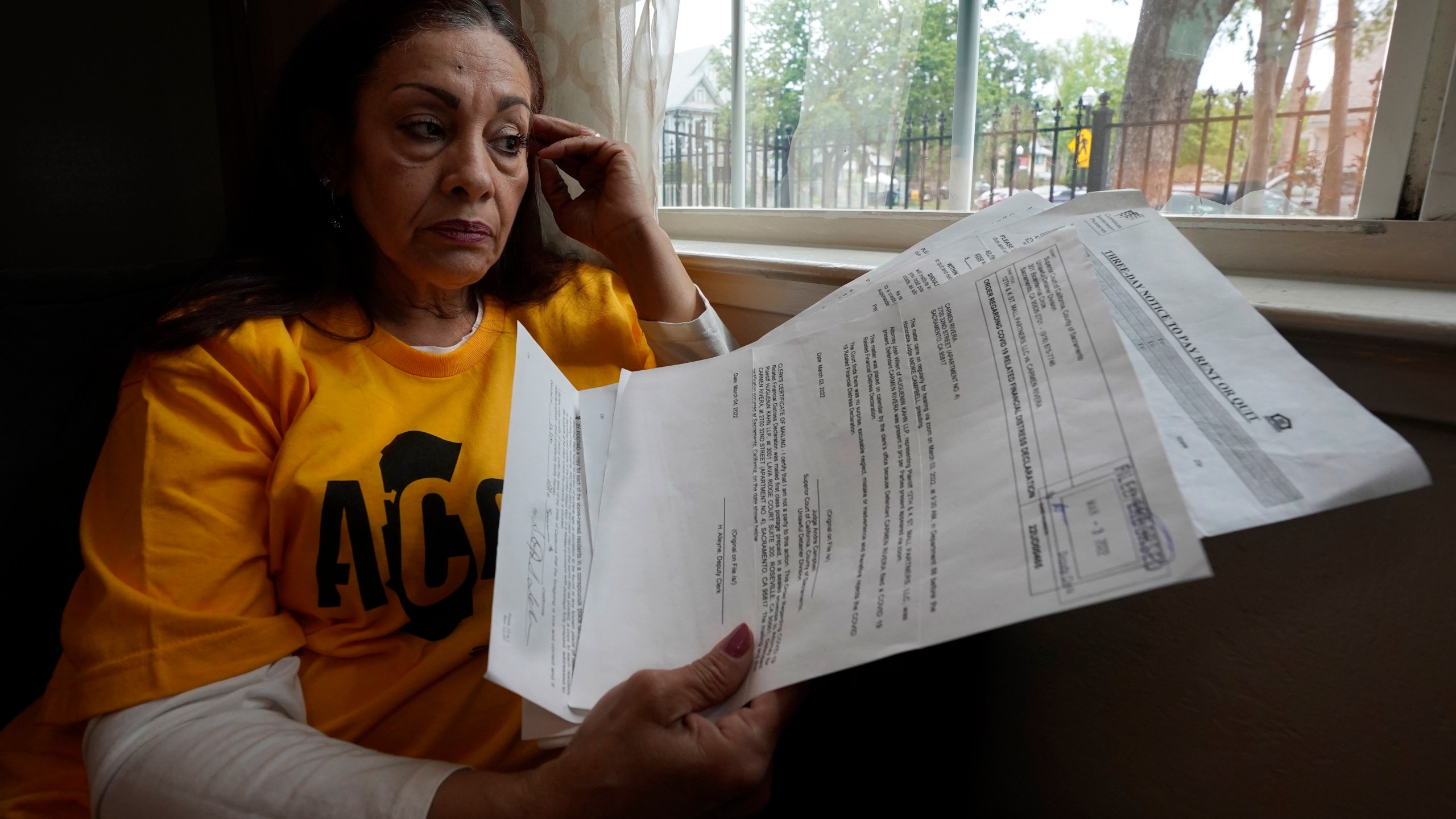 Carmen Rivera 54, displays some of the eviction notices she has received for her tiny apartment in Sacramento, Calif., Wednesday, March 30, 2022. A bill approved by the legislature on Thursday, March 31 2022, will stop people from being evicted from their homes through June 30 as long as they have applied for state assistance. Rivera has a pending application and is waiting to hear if she has been approved. Thursday is the last day to apply for assistance. (AP Photo/Rich Pedroncelli)