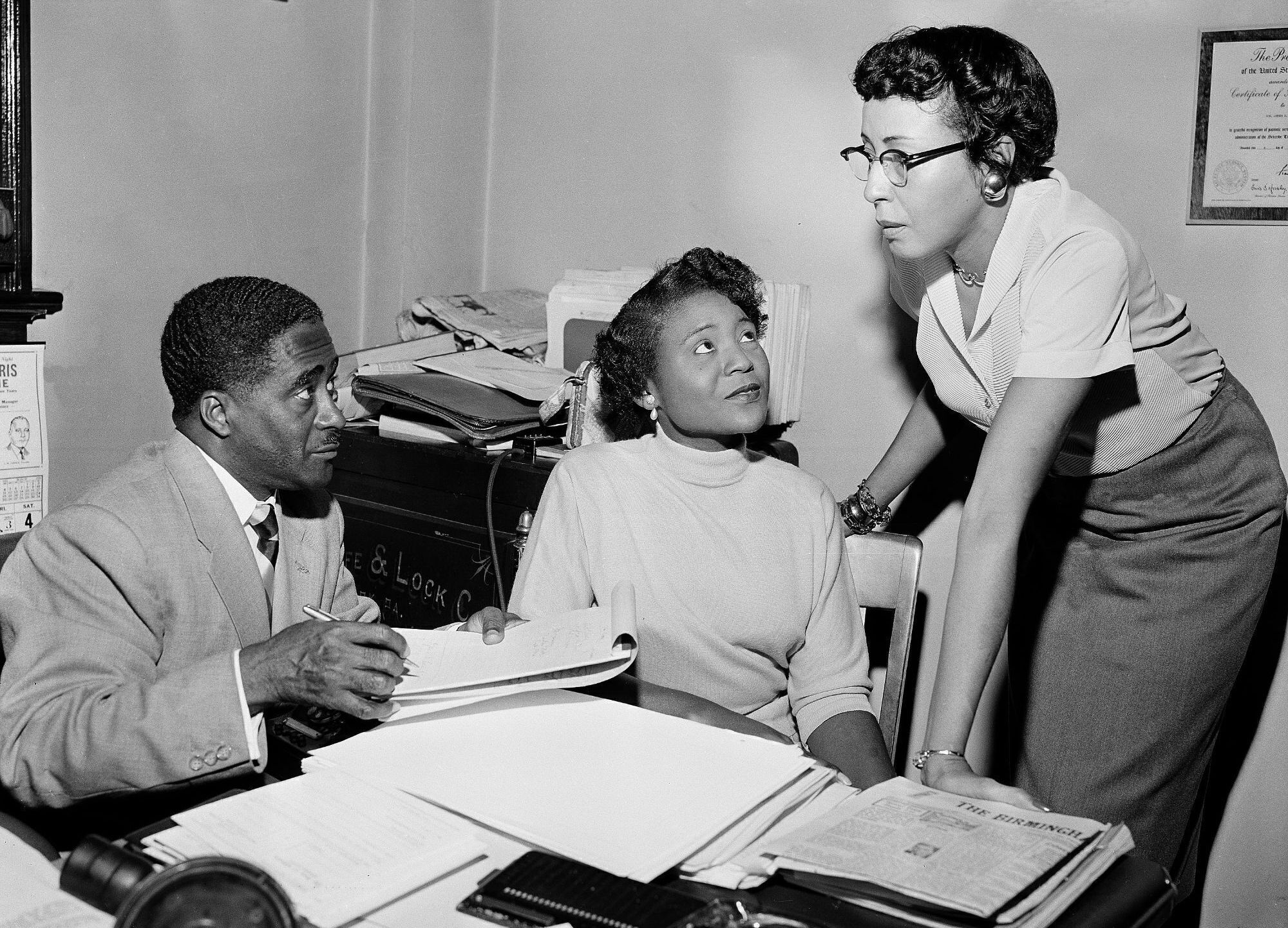 This file photo shows Autherine Lucy Foster, center, the first Black person to attend University of Alabama, discussing her return to campus following mob demonstrations in Birmingham, Ala., on Feb. 7, 1956. Angela Foster Dickerson, Foster's daughter, says her mother died Wednesday, March 2, 2022 and said a family statement would be released. (AP Photo/Gene Herrick, File)