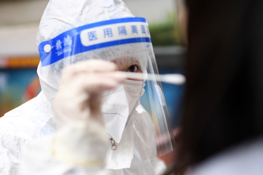 This file photo shows a medical worker getting a swab sample from a resident to test for the COVID-19 coronavirus in in China on Feb. 22, 2022. (STR/AFP via Getty Images)