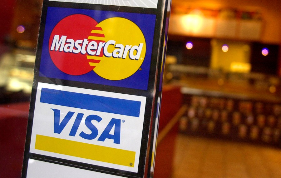 This April 22, 2005, file photo, shows logos for MasterCard and Visa credit cards at the entrance of a New York coffee shop. Mastercard and Visa are suspending their operations in Russia, the companies said Saturday, March 5, 2022, in the latest blow to the country's financial system after its invasion of Ukraine. (AP Photo/Mark Lennihan, File)