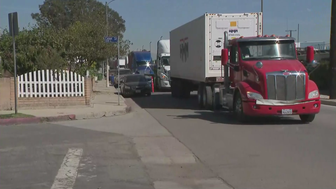 Big rigs line a narrow street in a Wilmington neighborhood on March 2, 2022. (KTLA)