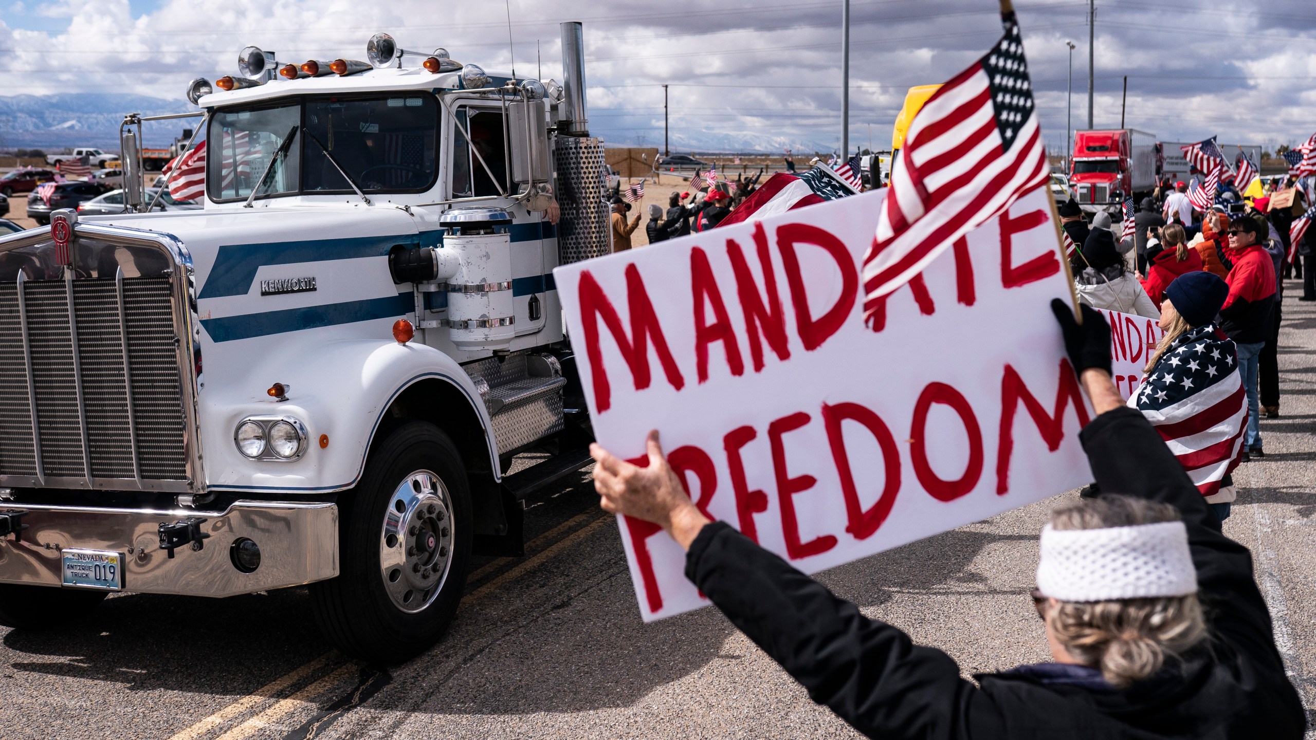 Supporters cheer on the beginning of a trucker caravan to Washington, D.C., called The People's Convoy on Wednesday, Feb. 23, 2022, in Adelanto, Calif. (AP Photo/Nathan Howard)