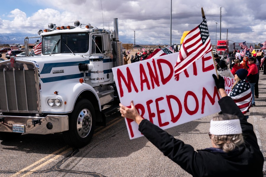 Supporters cheer on the beginning of a trucker caravan to Washington, D.C., called The People's Convoy on Wednesday, Feb. 23, 2022, in Adelanto, Calif. (AP Photo/Nathan Howard)