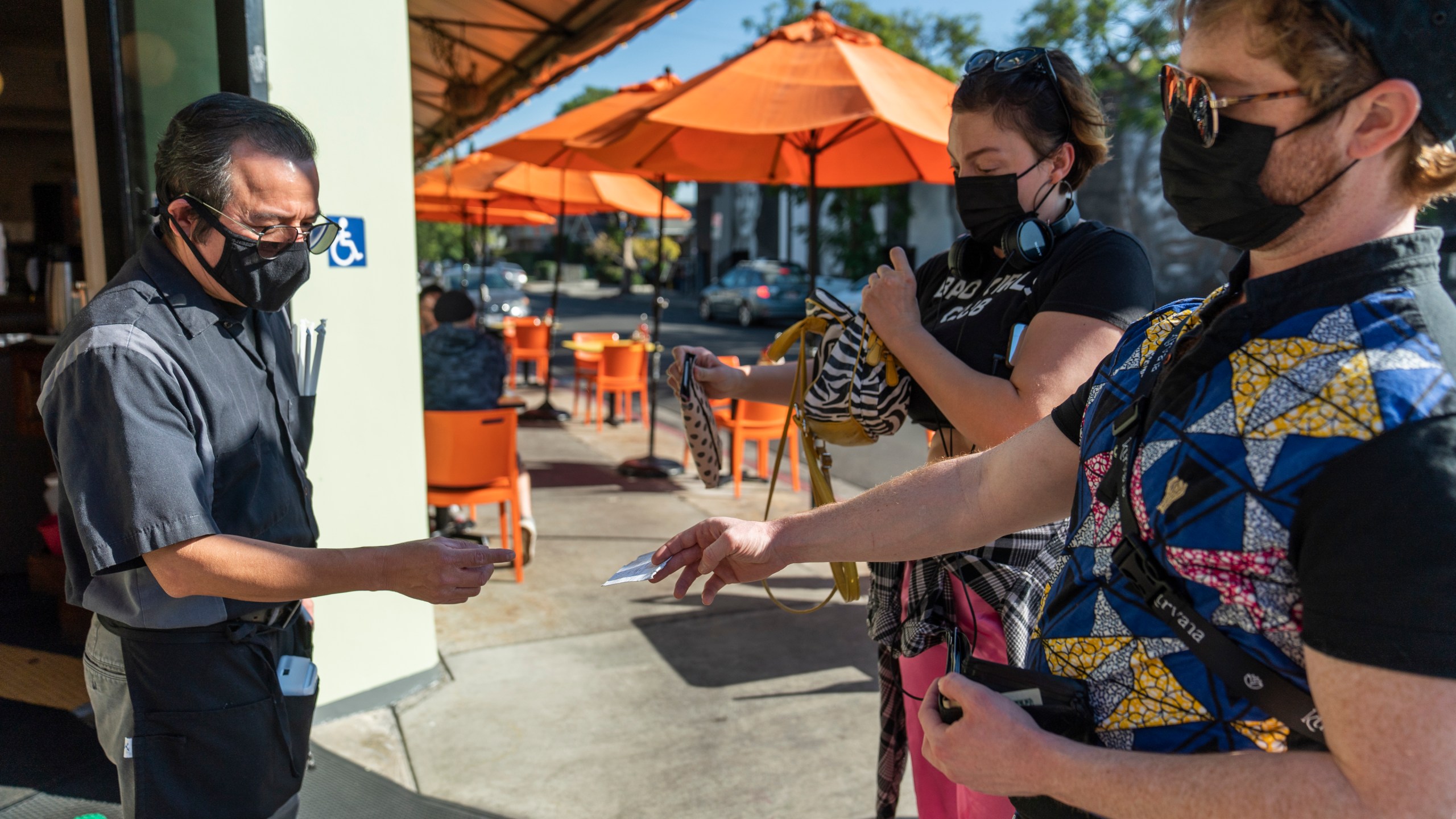 A waiter asks patrons to show their vaccination cards before entering the Fred 62 restaurant in Los Feliz on Nov. 29, 2021.(AP Photo/Damian Dovarganes, File)