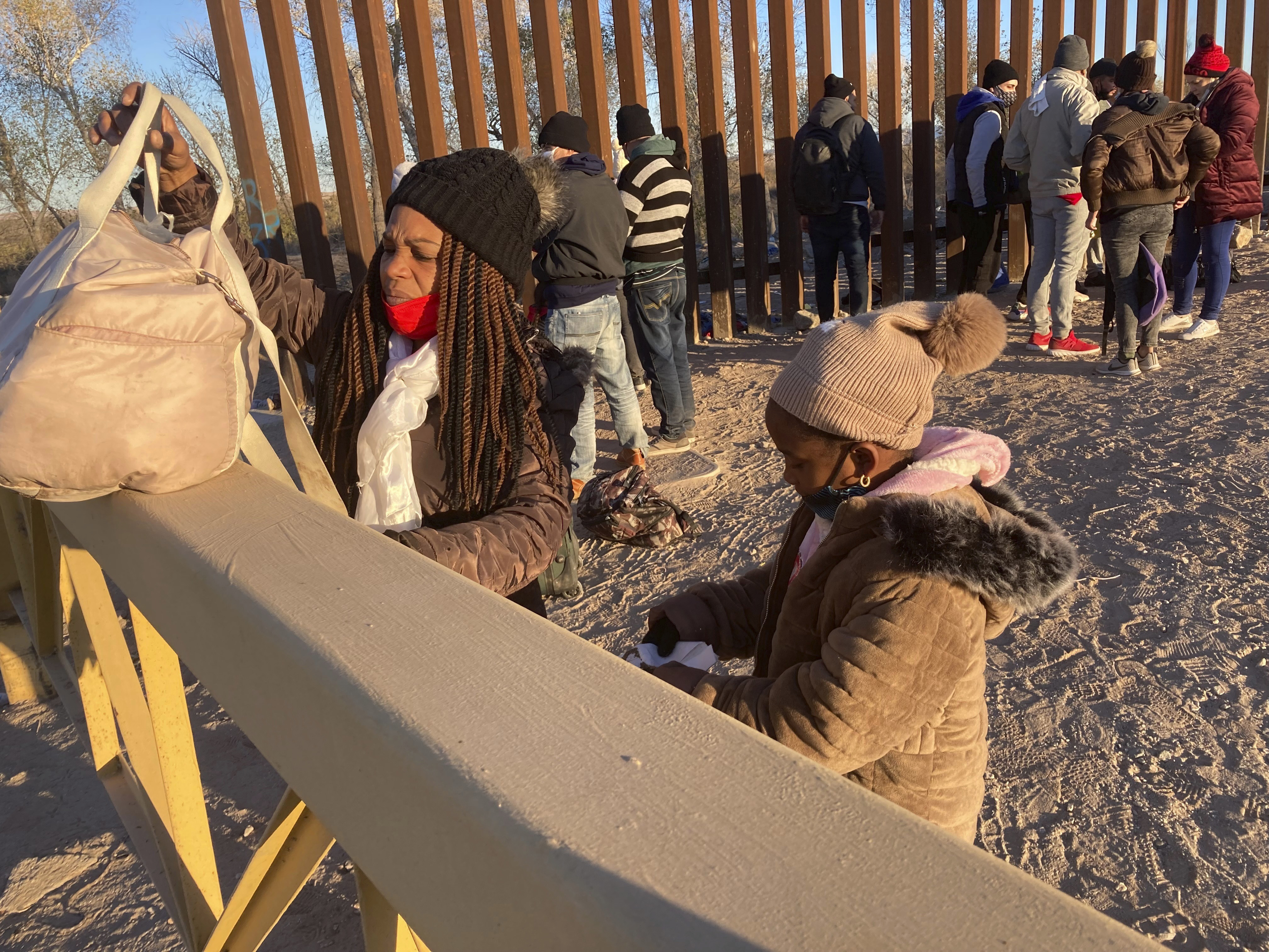 A Cuban woman and her daughter wait in line to be escorted to a Border Patrol van for processing in Yuma, Ariz., Feb. 6, 2022, hoping to remain in the United States to seek asylum. “This is a crisis, and in my estimation, because of a lack of planning from the administration, it’s about to get worse,” said Sen. Mark Kelly of Arizona. Kelly and fellow Arizona Democratic Sen. Kyrsten Sinema met Wednesday, March 30, with Homeland Security Secretary Alejandro Mayorkas to press their case for the administration to better plan and coordinate a response. (AP Photo/Elliot Spagat, File)