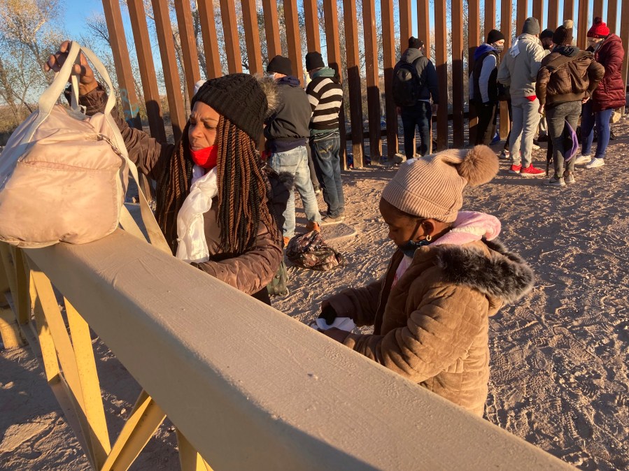 A Cuban woman and her daughter wait in line to be escorted to a Border Patrol van for processing in Yuma, Ariz., Feb. 6, 2022, hoping to remain in the United States to seek asylum. “This is a crisis, and in my estimation, because of a lack of planning from the administration, it’s about to get worse,” said Sen. Mark Kelly of Arizona. Kelly and fellow Arizona Democratic Sen. Kyrsten Sinema met Wednesday, March 30, with Homeland Security Secretary Alejandro Mayorkas to press their case for the administration to better plan and coordinate a response. (AP Photo/Elliot Spagat, File)