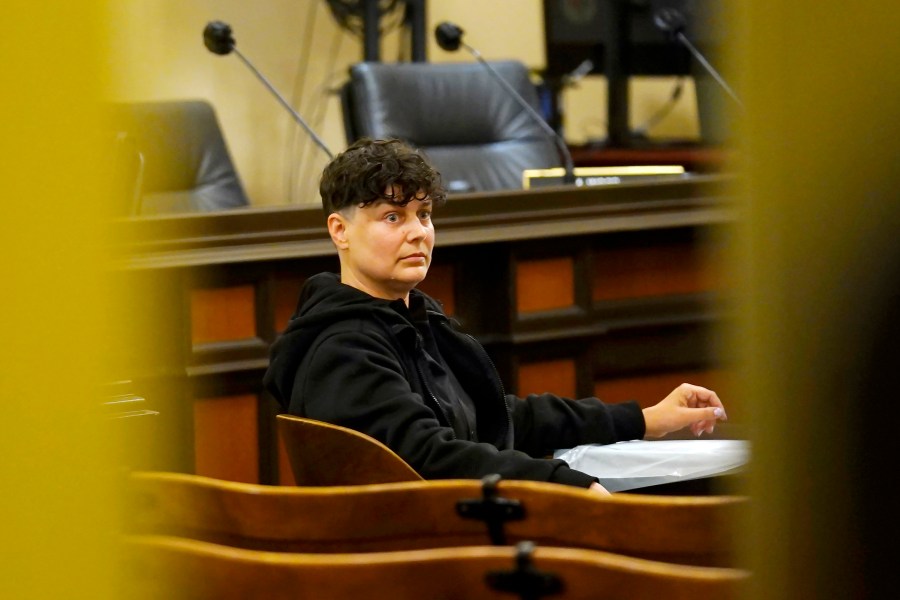 Carla Cabral sits at a table after disrupting a hearing of the Assembly Agriculture Committee in Sacramento, Calif., on April 6, 2022. Cabral, an animal rights organizer, glued her hand to a table and refused to leave. (AP Photo/Rich Pedroncelli)