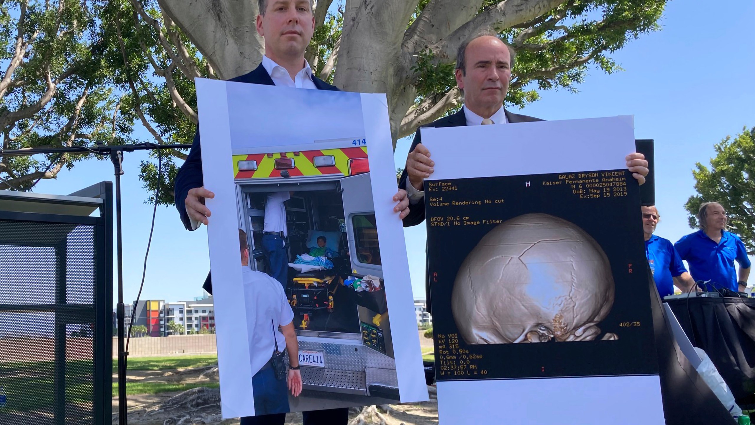 Attorney Keith Bruno, left, and Kyle Scott, representing the Galaz family, hold up a photo of Bryson Galaz and imaging of his skull during a press conference in Anaheim, Calif. on April 7, 2022. (AP Photo/Amy Taxin)