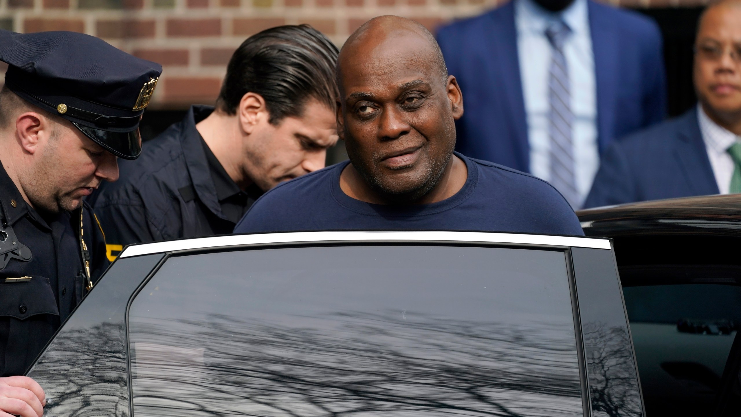 Law enforcement officials lead subway shooting suspect Frank R. James, 62, center right, away from a police station and into a vehicle, in New York on April 13, 2022. (John Minchillo/Associated Press)