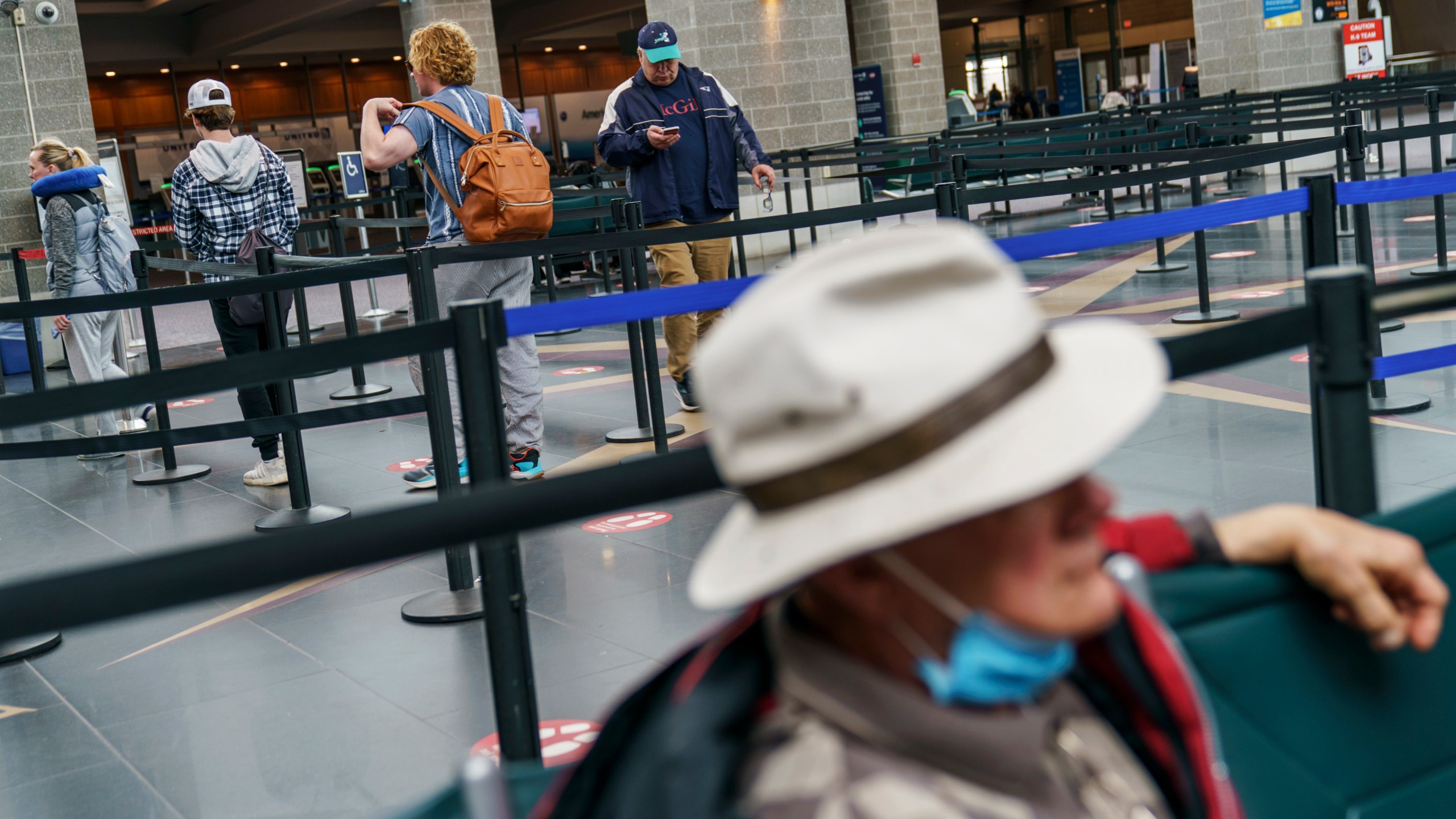 Travelers enter a security line at Rhode Island T.F. Green International Airport in Providence, R.I. on April 19, 2022. (David Goldman/Associated Press)