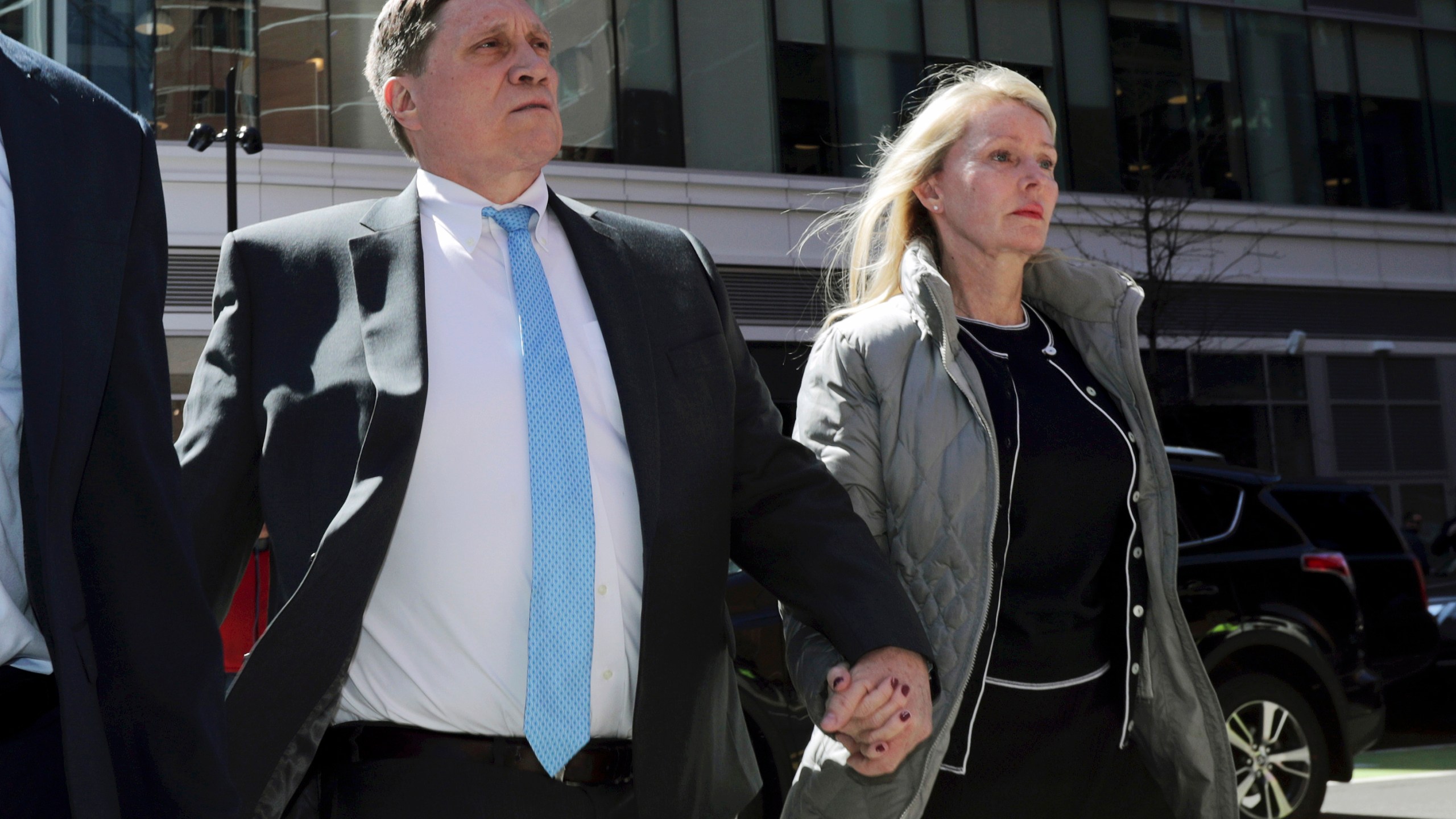 John Wilson, left, arrives at federal court, April 3, 2019, with his wife Leslie to face charges in a nationwide college admissions bribery scandal in Boston. (AP Photo/Charles Krupa, File)