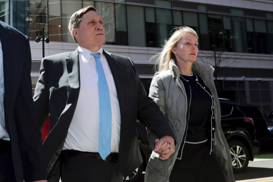 John Wilson, left, arrives at federal court, April 3, 2019, with his wife Leslie to face charges in a nationwide college admissions bribery scandal in Boston. (AP Photo/Charles Krupa, File)