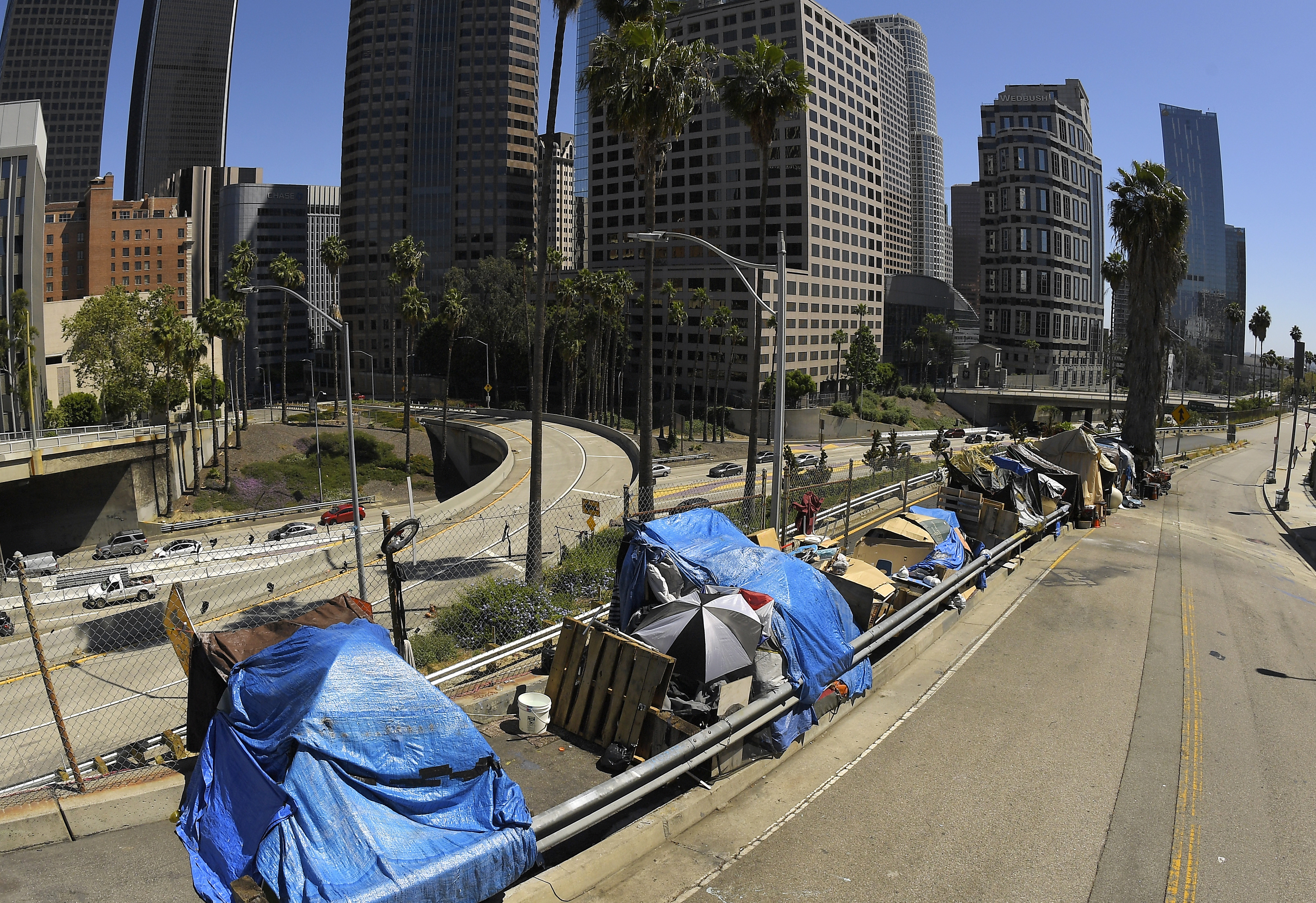 This May 21, 2020, file photo shows a homeless encampment on Beaudry Avenue as traffic moves along Interstate 110 below during the coronavirus outbreak, in downtown Los Angeles. (AP Photo/Mark J. Terrill,File)