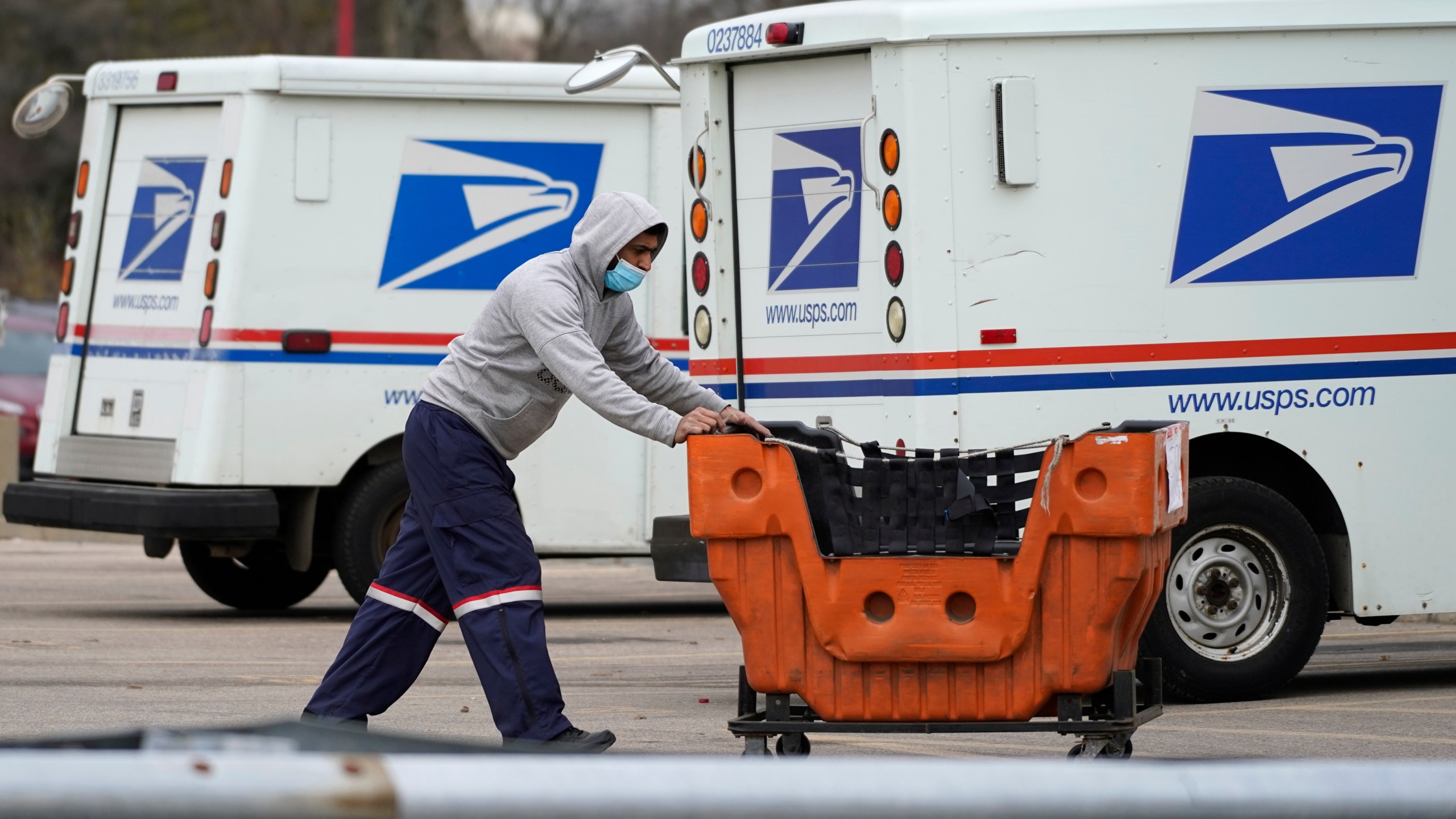 A United States Postal Service employee works outside a post office in Wheeling, Ill. on Dec. 3, 2021. (Nam Y. Huh/Associated Press)