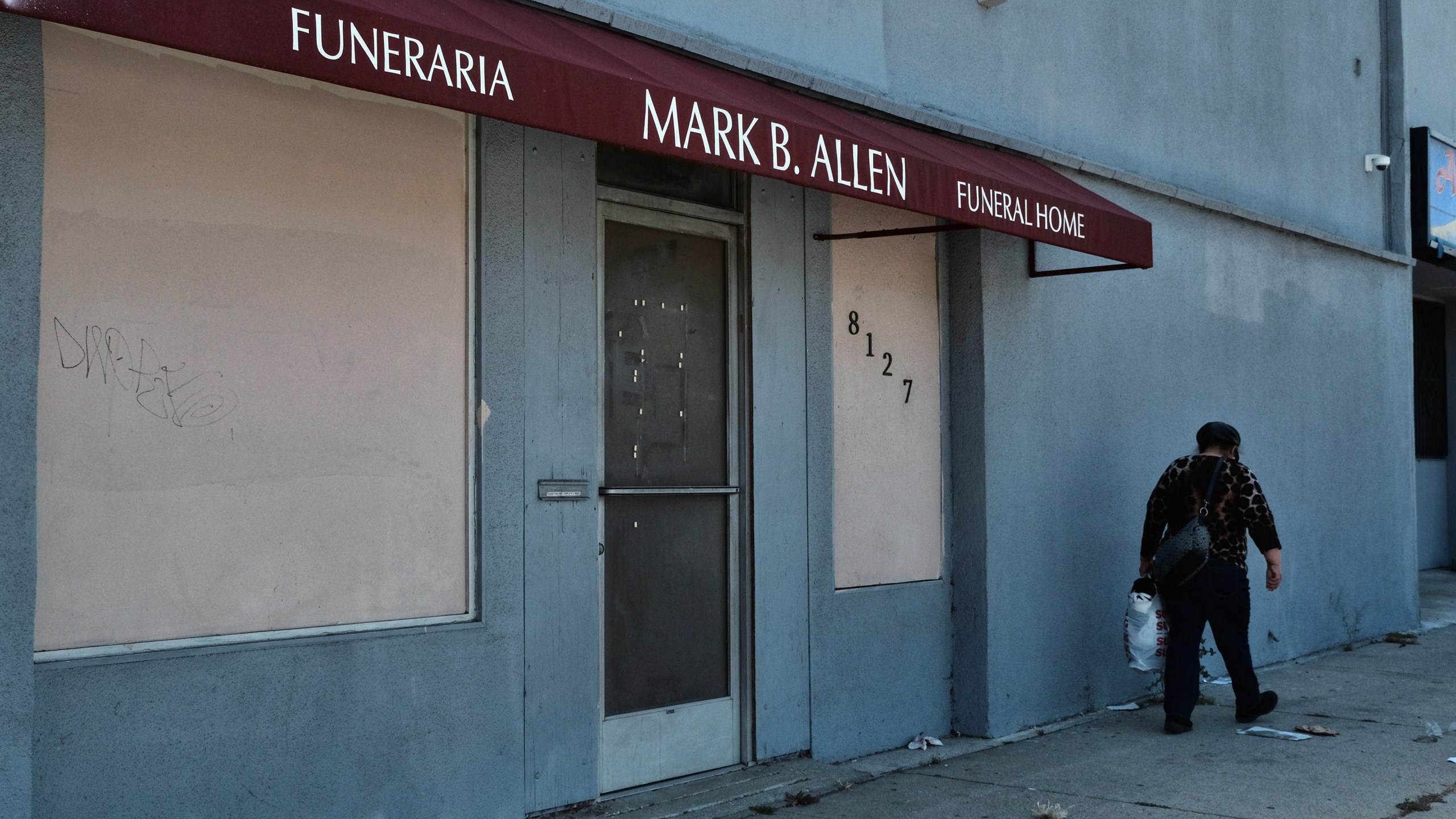 A pedestrian walk past the Mark B. Allen Funeral Home in the Sun Valley section of Los Angeles on April 29, 2022. (AP Photo/Richard Vogel)