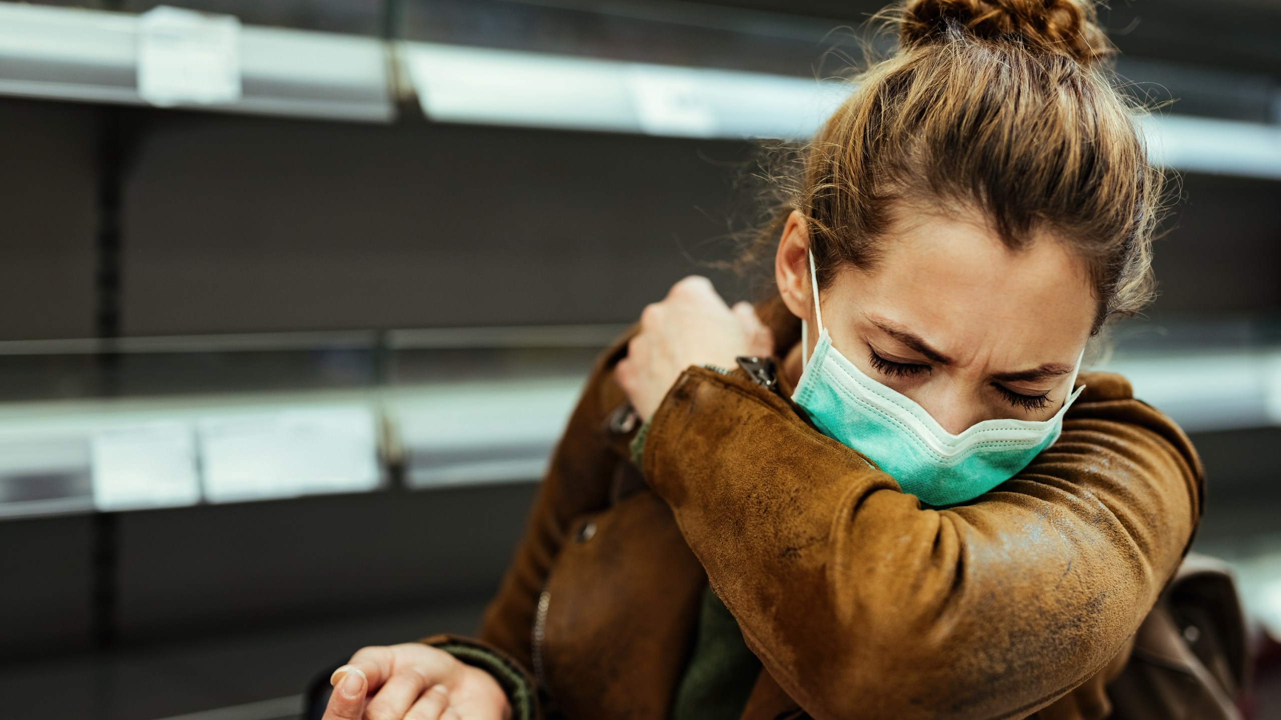 A woman coughs while wearing a face mask in this file photo. (Getty Images)