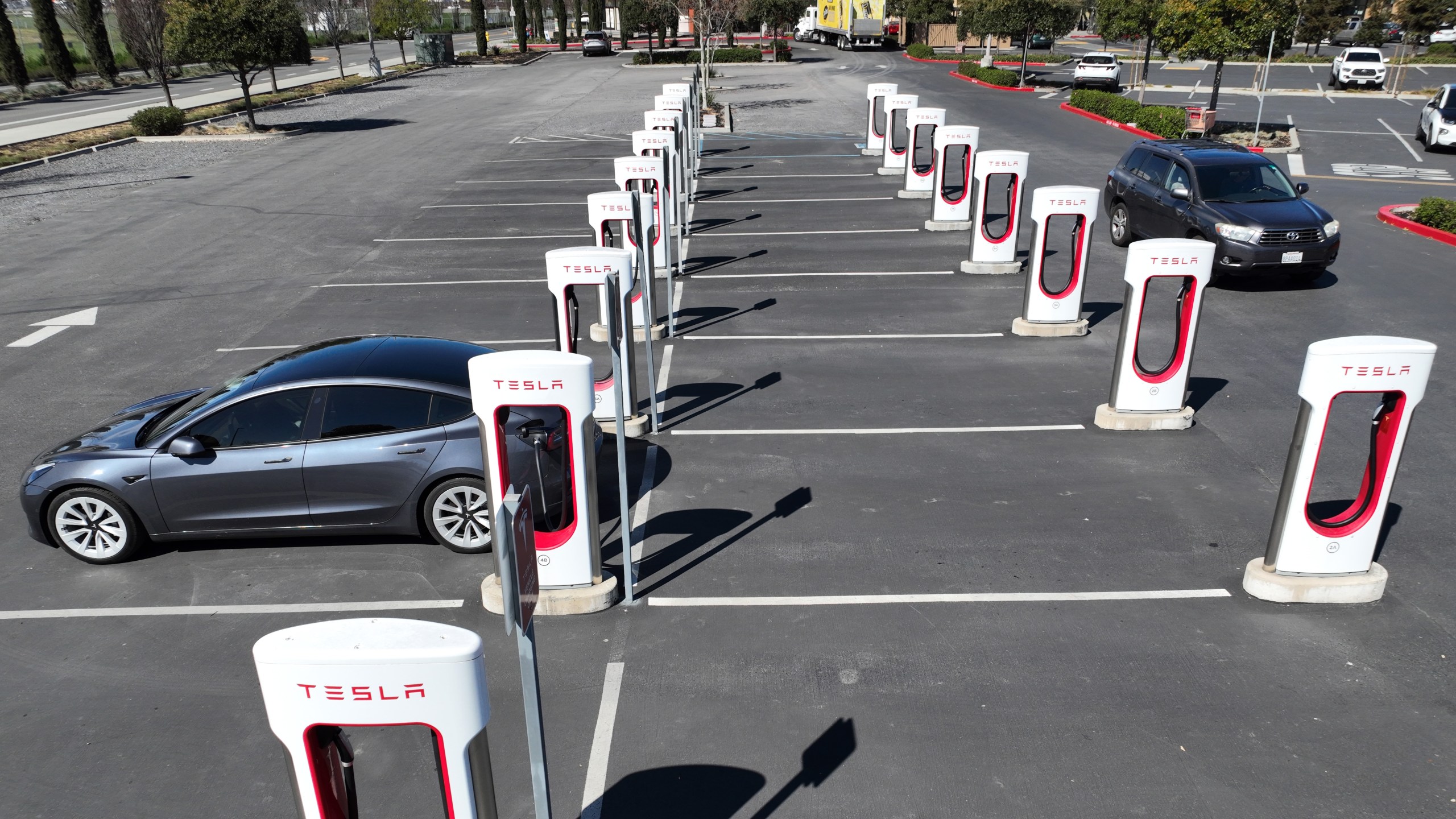 In an aerial view, a Tesla car recharges its battery at a Supercharger location on March 9, 2022 in Petaluma, California. (Justin Sullivan/Getty Images)