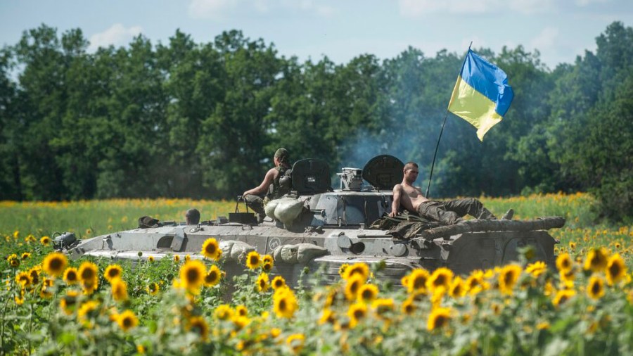 Ukrainian troops ride on an APC with a Ukrainian flag, in a field with sunflowers in Kryva Luka, eastern Ukraine, on July 5, 2014. Prices for food commodities like grains and vegetable oils reached their highest levels ever last month because of Russia's war in Ukraine and the “massive supply disruptions” it is causing, the United Nations said Friday, April 8, 2022. (AP Photo/Evgeniy Maloletka)