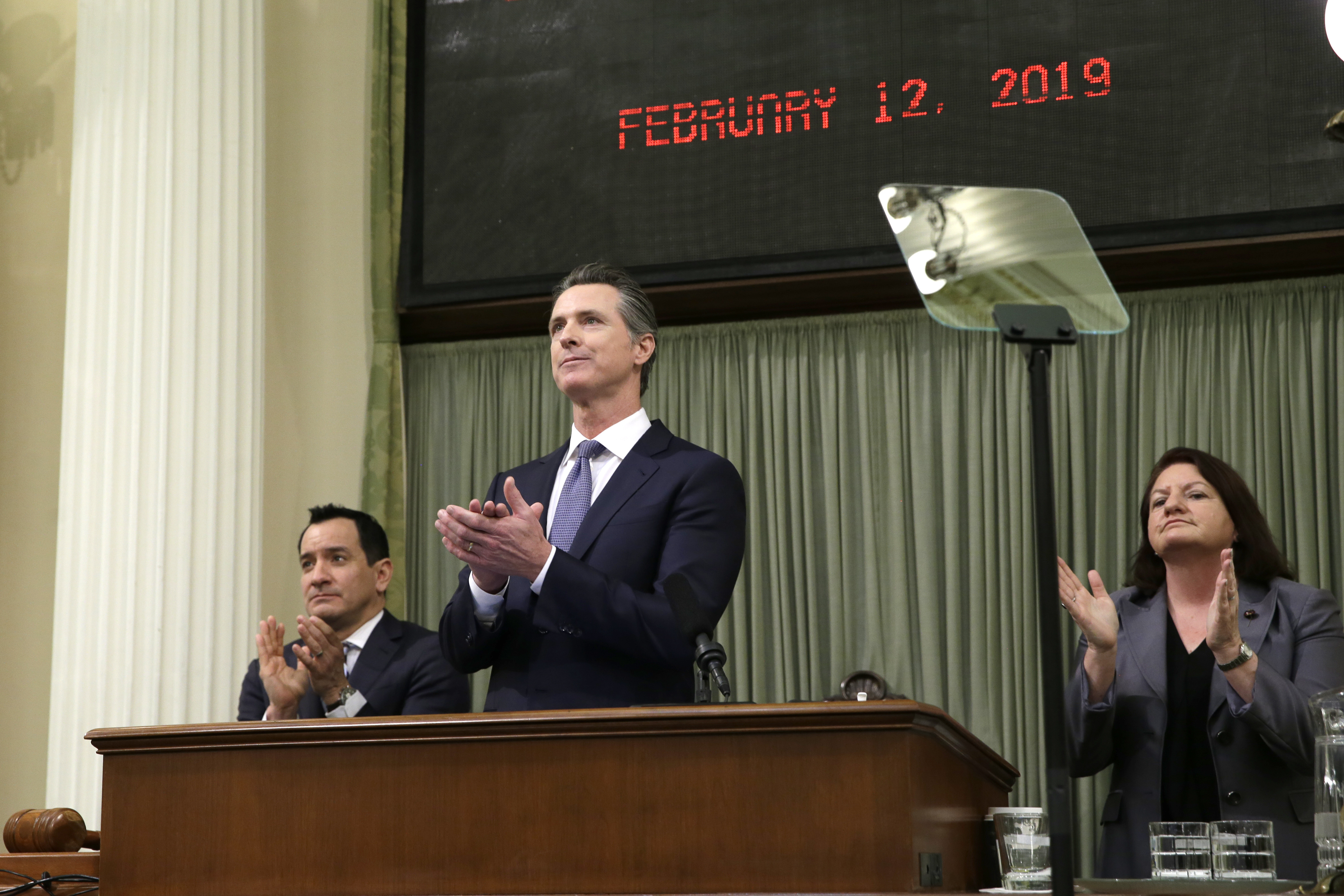 California Gov. Gavin Newsom, flanked by Assembly Speaker Anthony Rendon, left, and Senate President Pro Tempore Toni Atkins, right, applaud as introductions are made during Newsom's first State of the State address at the Capitol, on, Feb. 12, 2019. (Rich Pedroncelli/Associated Press)