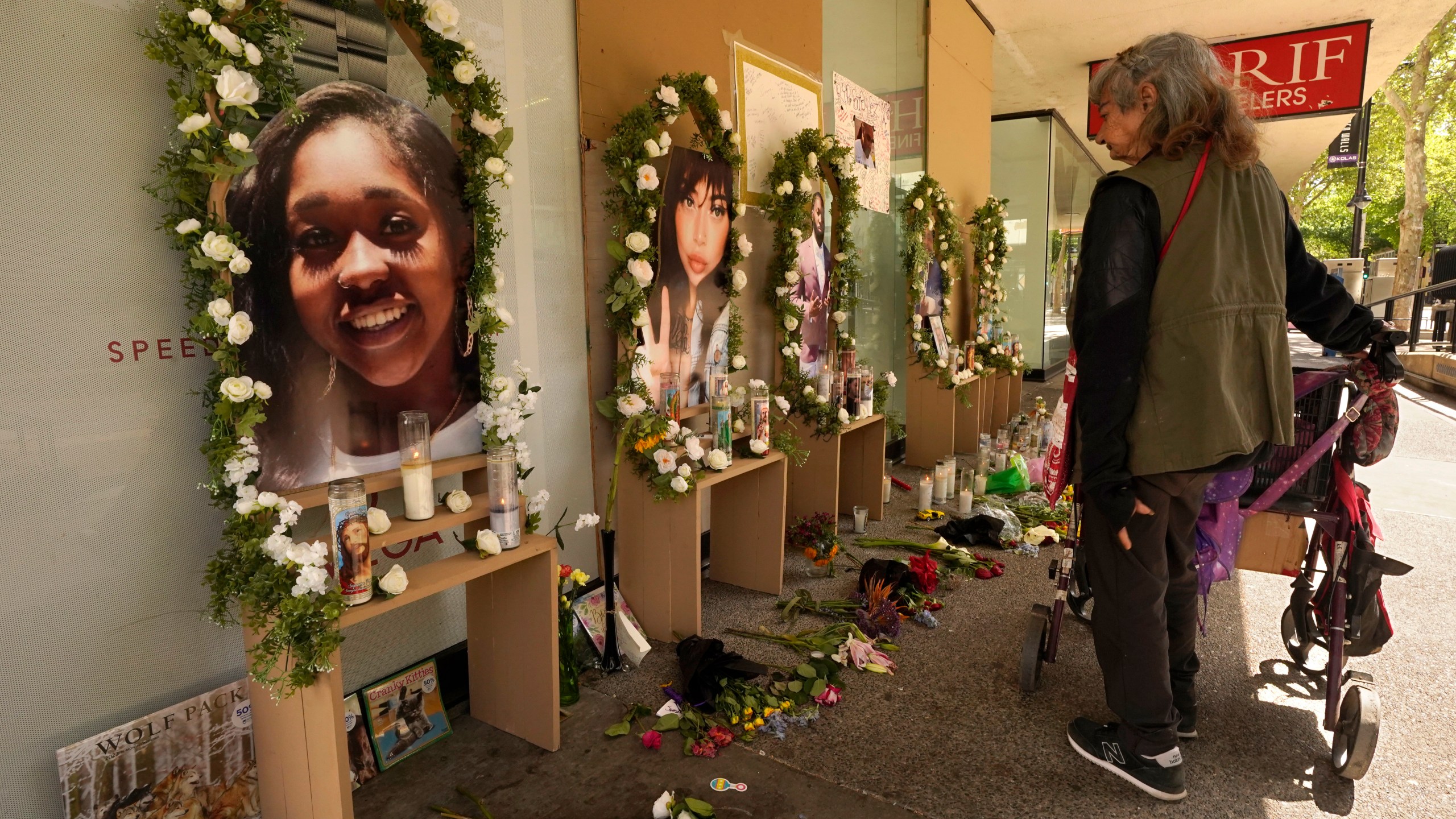 A passerby pauses at a memorial for the people killed in mass shooting in Sacramento, Calif., April 6, 2022. Prosecutors have filed murder charges in a mass shooting that rocked California’s capital city a month ago. District Attorney Anne Marie Schubert said Tuesday, May 3, that three men have been charged with murder in the slayings. (AP Photo/Rich Pedroncelli, File)