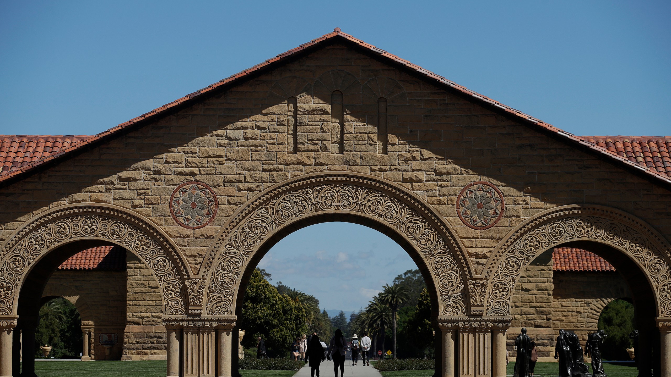 Pedestrians walk on the campus at Stanford University in Stanford, Calif., April 9, 2019. (AP Photo/Jeff Chiu, File)