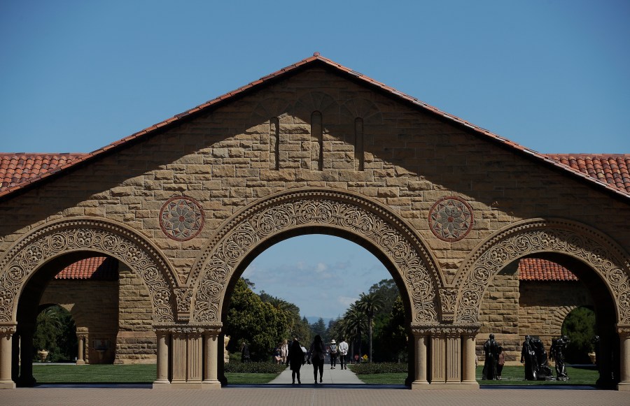 Pedestrians walk on the campus at Stanford University in Stanford, Calif., April 9, 2019. (AP Photo/Jeff Chiu, File)