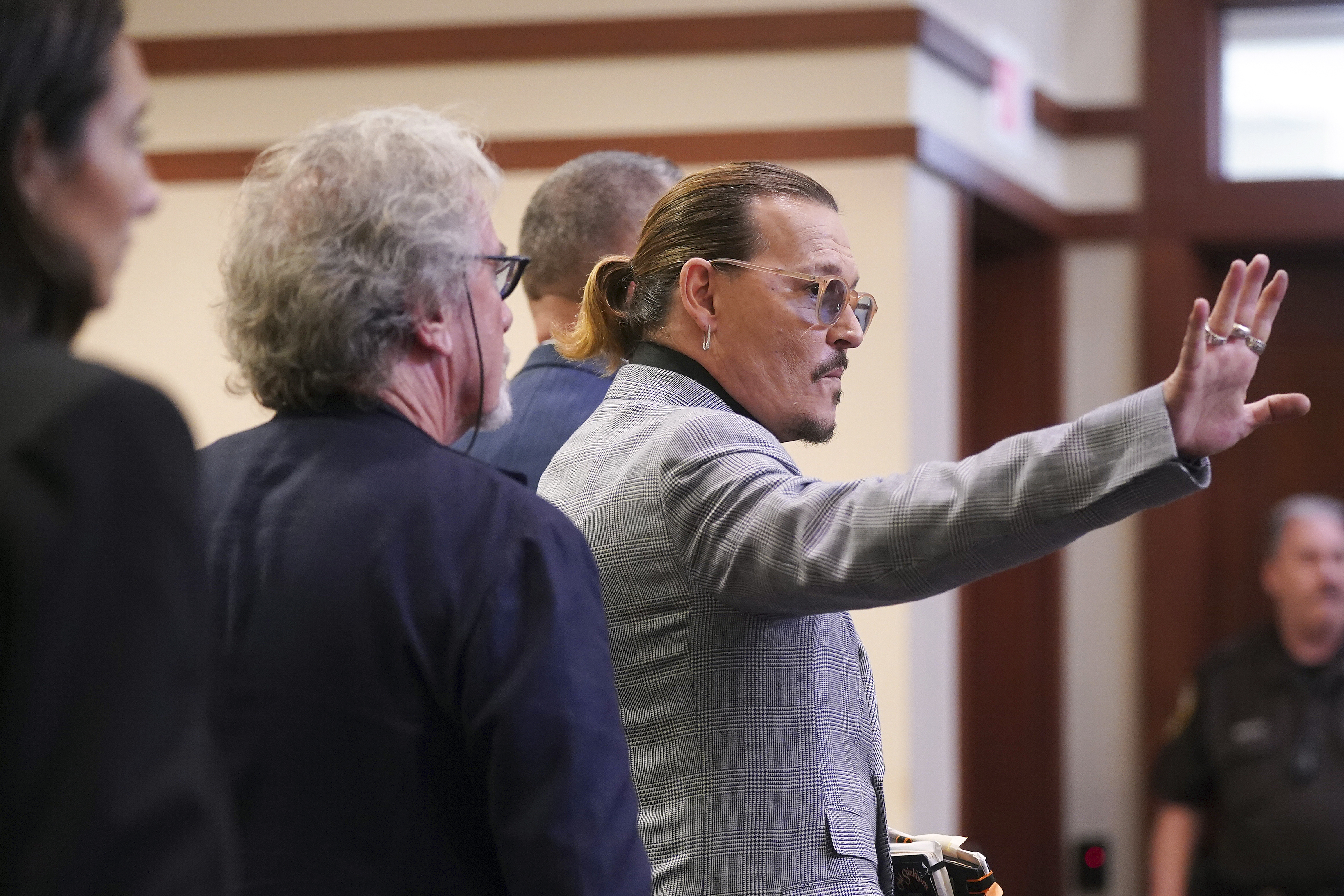 Actor Johnny Depp waves as he leaves the courtroom at the Fairfax County Circuit Courthouse in Fairfax, Va., Thursday, May 19, 2022. Actor Johnny Depp sued his ex-wife Amber Heard for libel in Fairfax County Circuit Court after she wrote an op-ed piece in The Washington Post in 2018 referring to herself as a "public figure representing domestic abuse." (Shawn Thew/Pool Photo via AP)