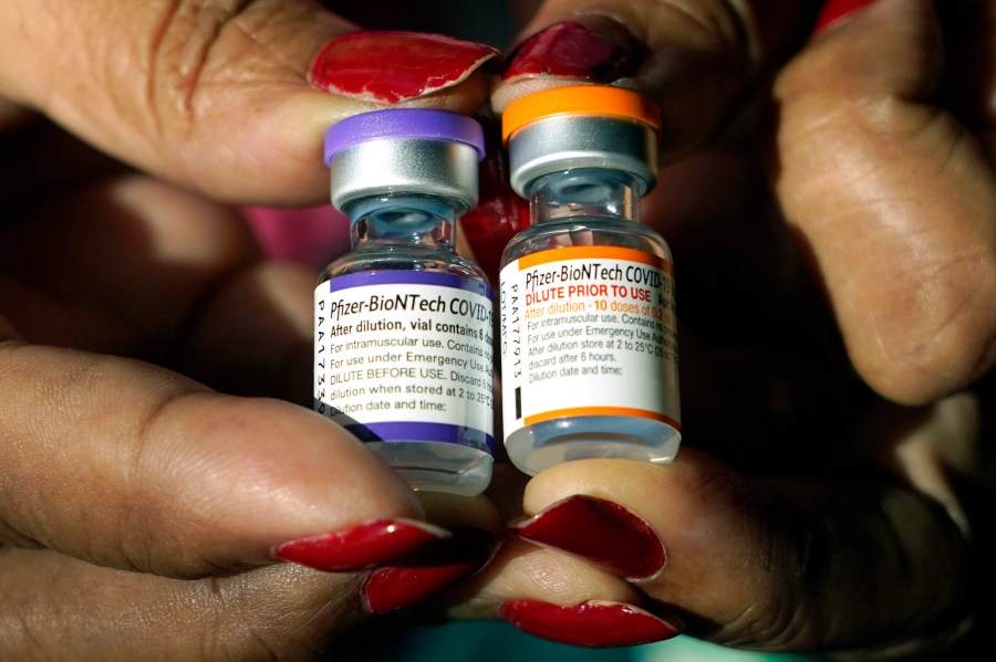 A nurse holds a vial of the Pfizer COVID-19 vaccine for children ages 5 to 11, right, and a vial of the vaccine for adults, which has a different colored label, at a vaccination station in Jackson, Miss., Tuesday, Feb. 8, 2022. (AP Photo/Rogelio V. Solis, File)