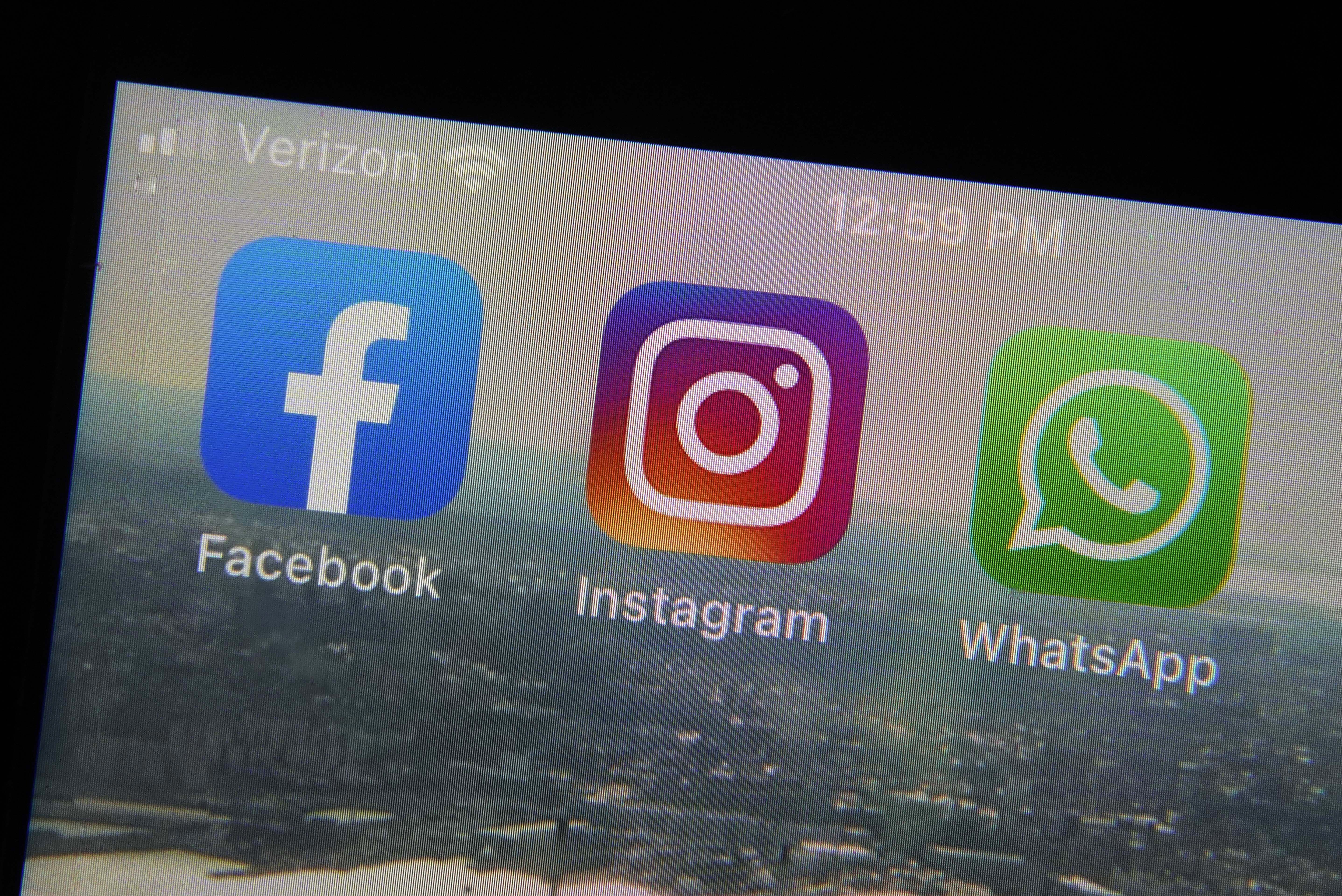 The mobile phone apps for, from left, Facebook, Instagram and WhatsApp are shown on a device in New York. The company that owns Facebook and Instagram said it will begin revealing more details about how advertisers target people with certain political ads, just months before the U.S. Midterm elections. (Richard Drew/Associated Press)