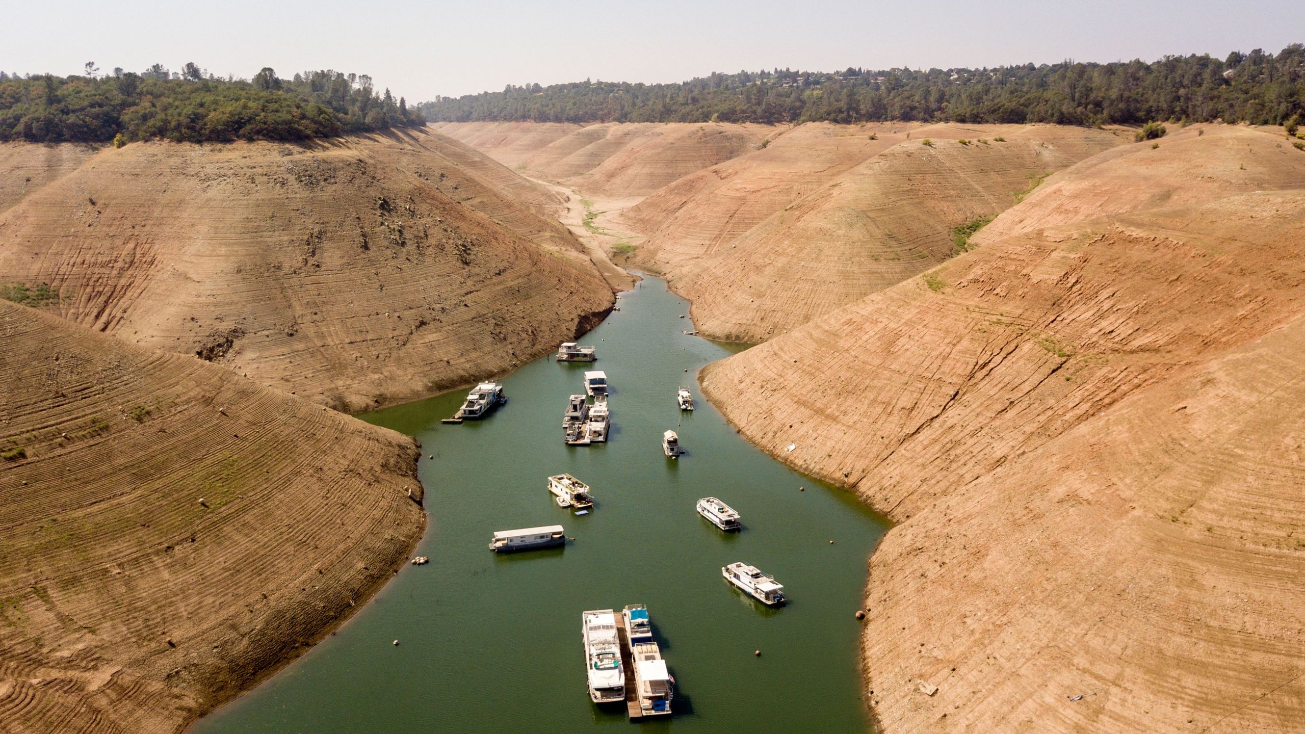 Houseboats sit in a narrow section of water in a depleted Lake Oroville on Sept. 5, 2021. (JOSH EDELSON/AFP via Getty Images)