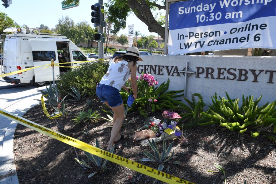 A woman places flowers at a makeshift memorial outside the Geneva Presbyterian Church May 16, 2022 after one person was killed and five injured during a shooting. (ROBYN BECK/AFP via Getty Images)