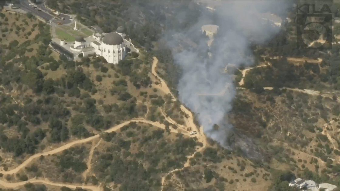 The Griffith Observatory is seen in the background as smoke from a small fire rises on May 17, 2022. (KTLA)